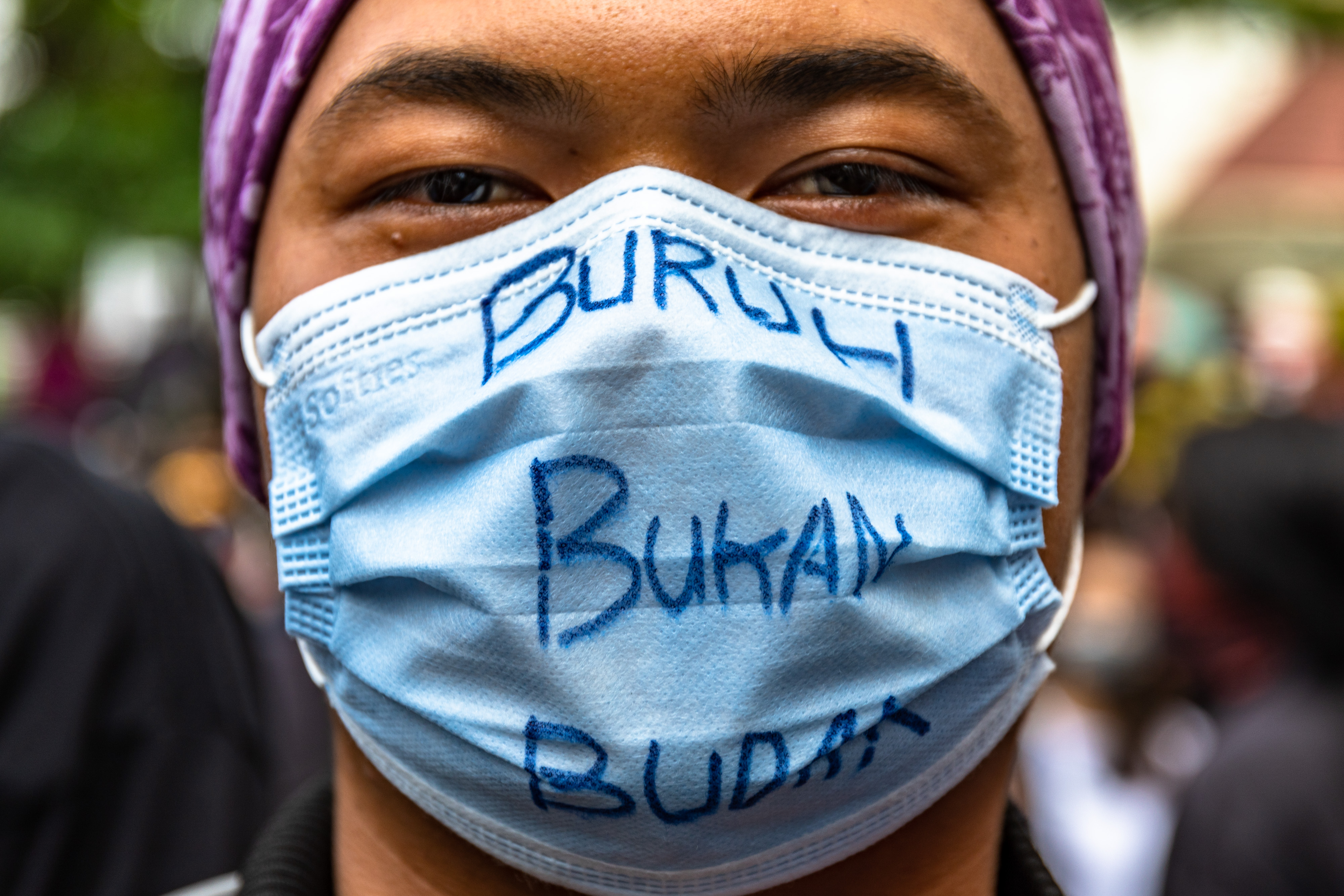 Pengunjuk rasa RUU Cipta Kerja mengenakan masker dengan tulisan Buruh Bukan Budak