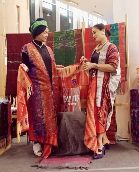 Desainer Hetty Sinaga (kiri) memamerkan karya fesyen dengan merek Damiten yang terbuat dari kain tenun.