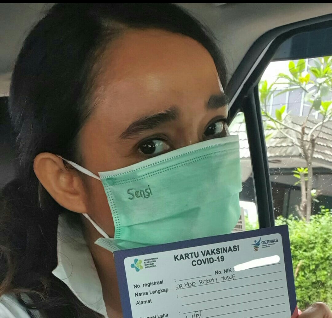Psikiater Nova Riyanti Yusuf bermasker dan menunjukkan kartu bahwa ia sudah menjalani vaksinasi covid-19 27 Januari 2021.