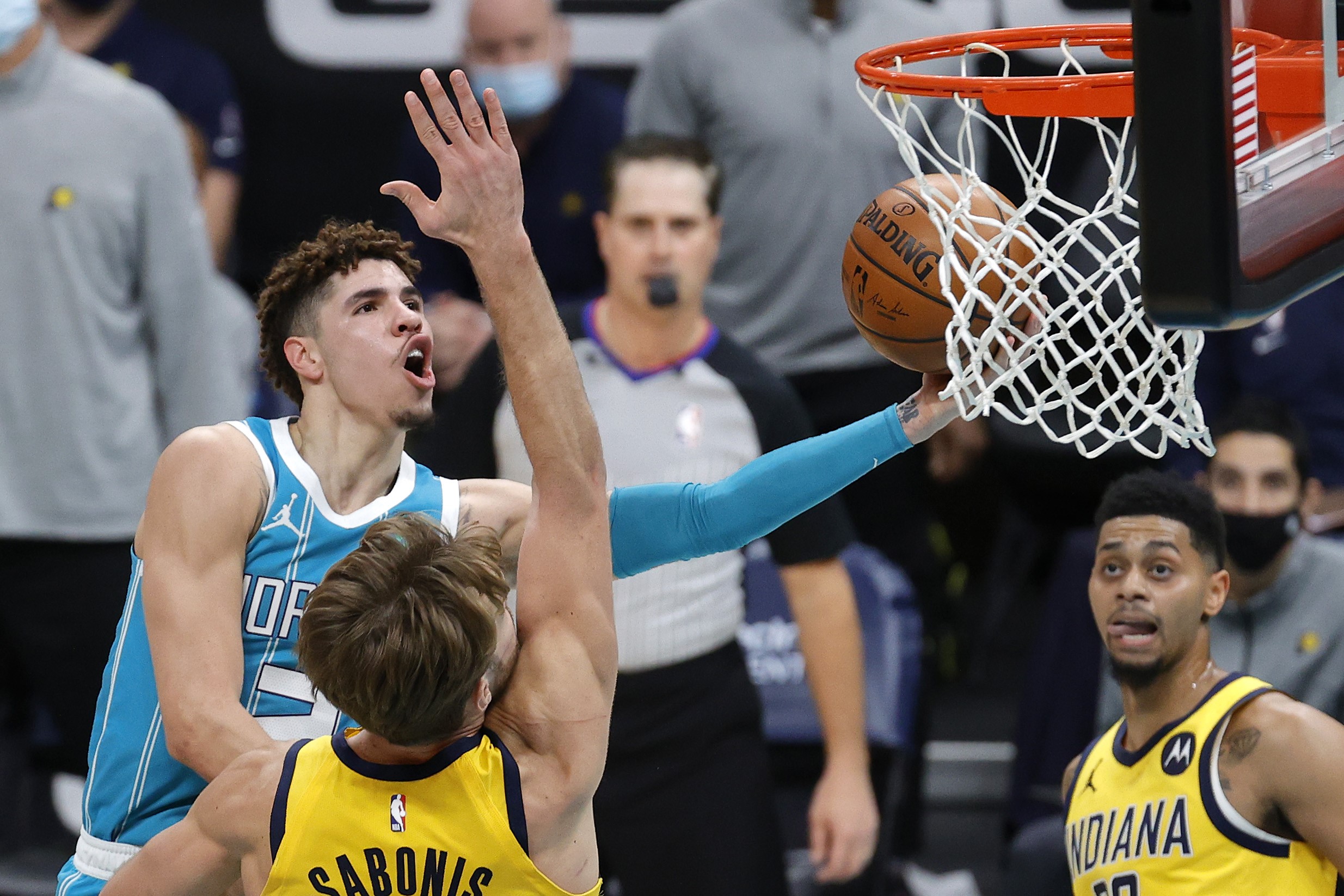  LaMelo Ball (kiri) dari Charlotte Hornets berusaha menjaring bola dengan dihalangi pemain Indiana Pacers.