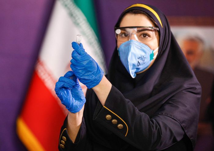   Seorang tenaga kesehatan di Iran mengikuti uji coba vaksin tahap pertama di negaranya pada Desember 2020.  