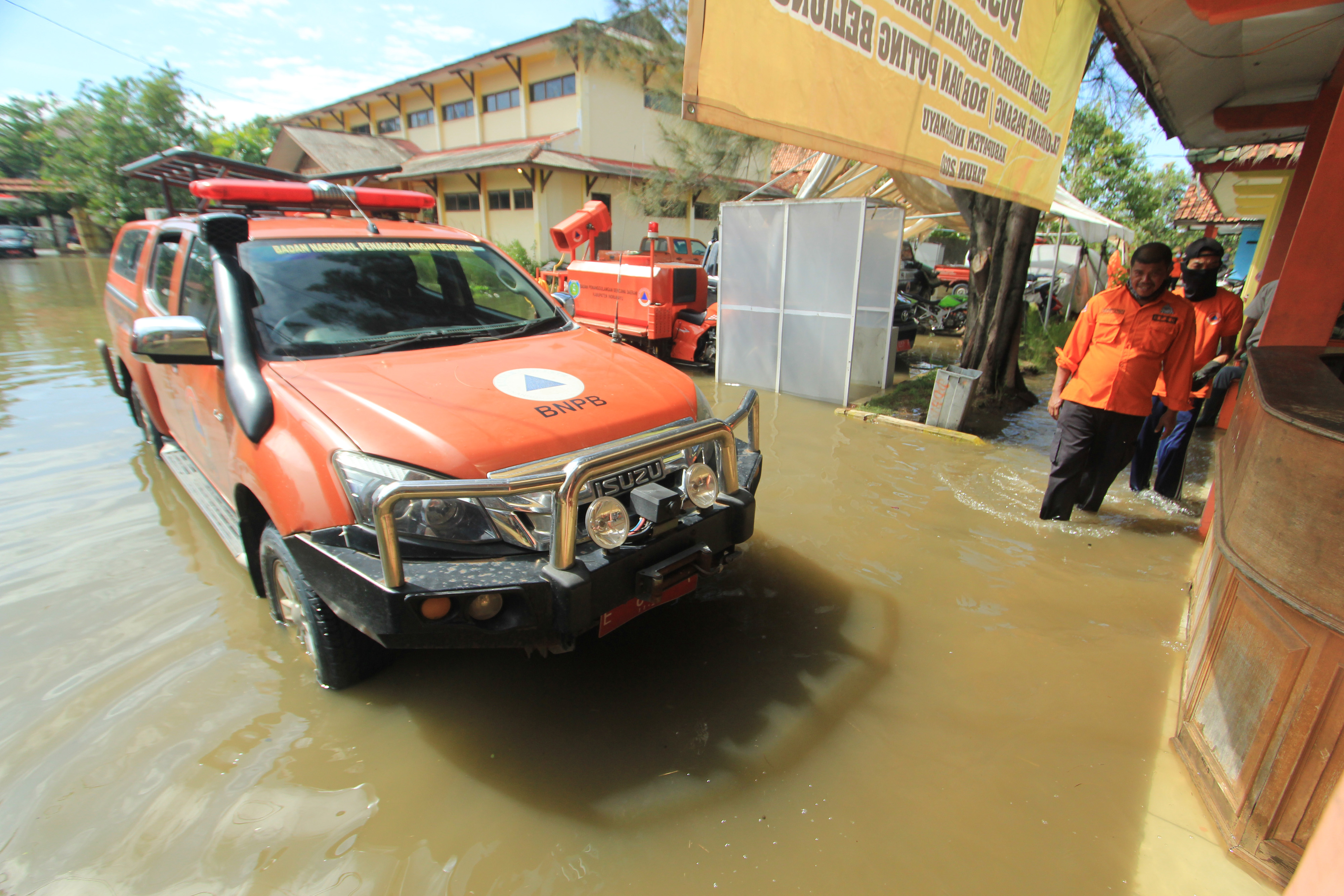 Petugas berada di sekitar kantor BPBD yang terendam banjir di Indramayu, Jawa Barat, kemarin.