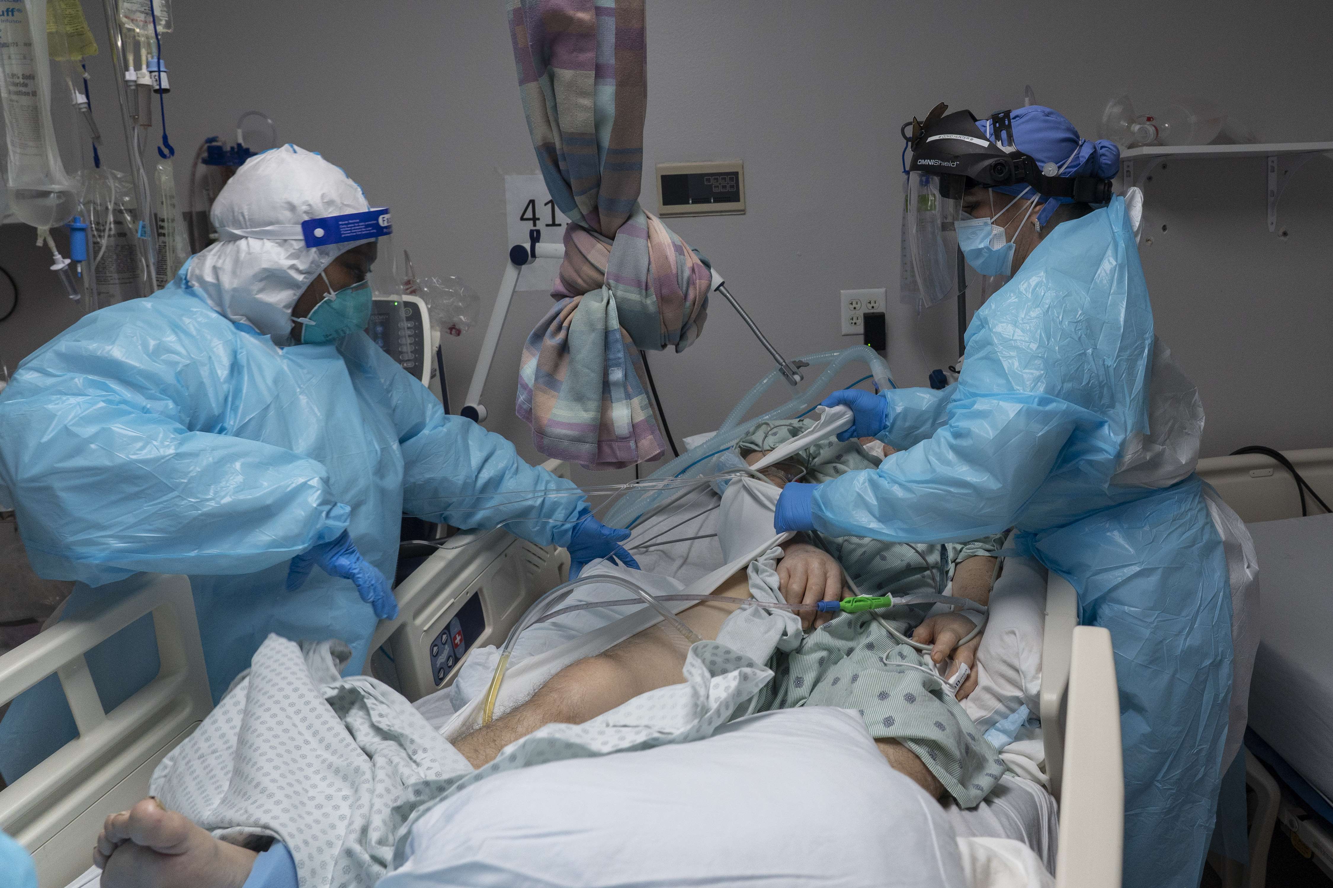 Anggota staf medis Shudylyn McHargh dan Tanna Ingraham merawat pasien di unit perawatan intensif (ICU) COVID-19 pada Malam Tahun Baru  