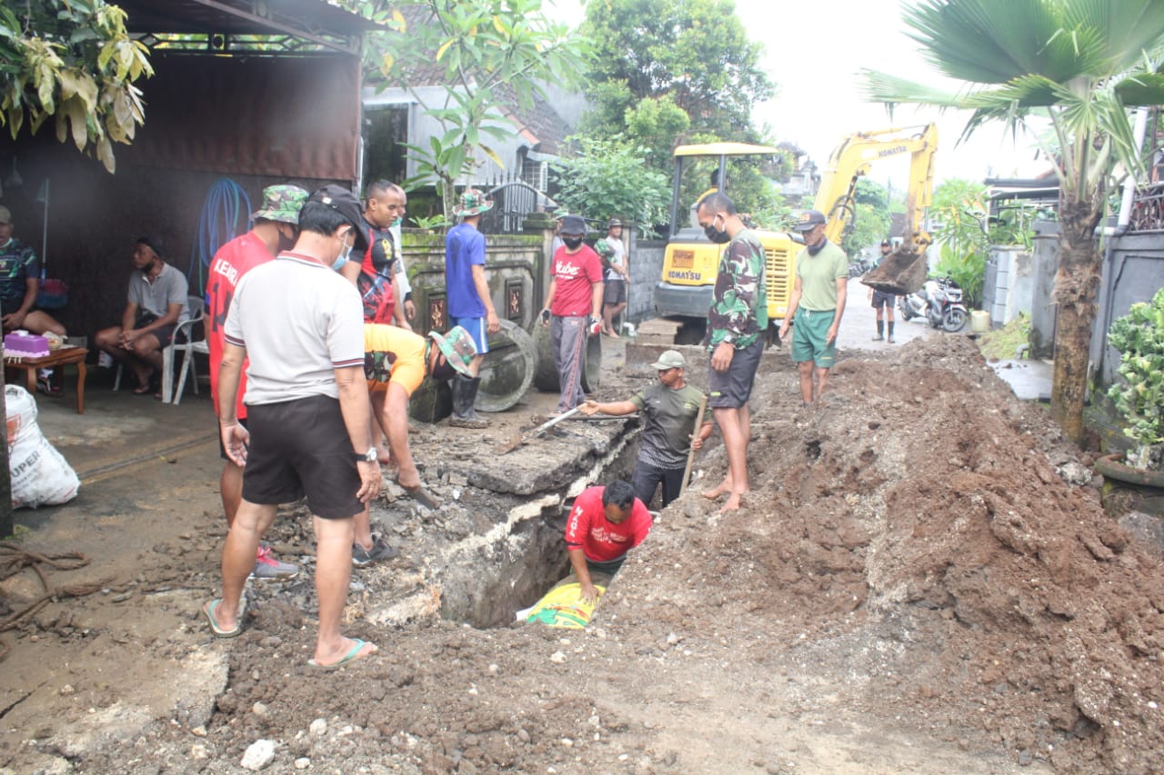 Warga dan TNI bergotong royong membenahi saluran air di Perumahan Lebah Sari, Tabanan, Bali, Jumat (22/1/2021)