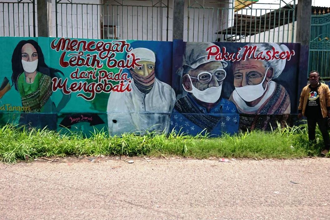 Pesan mural protokol kesehatan yang terletak di di Jalan Don Juang, Kelurahan Kota Uneng, Kecamatan Alok, Kabupaten Sikka, NTT.