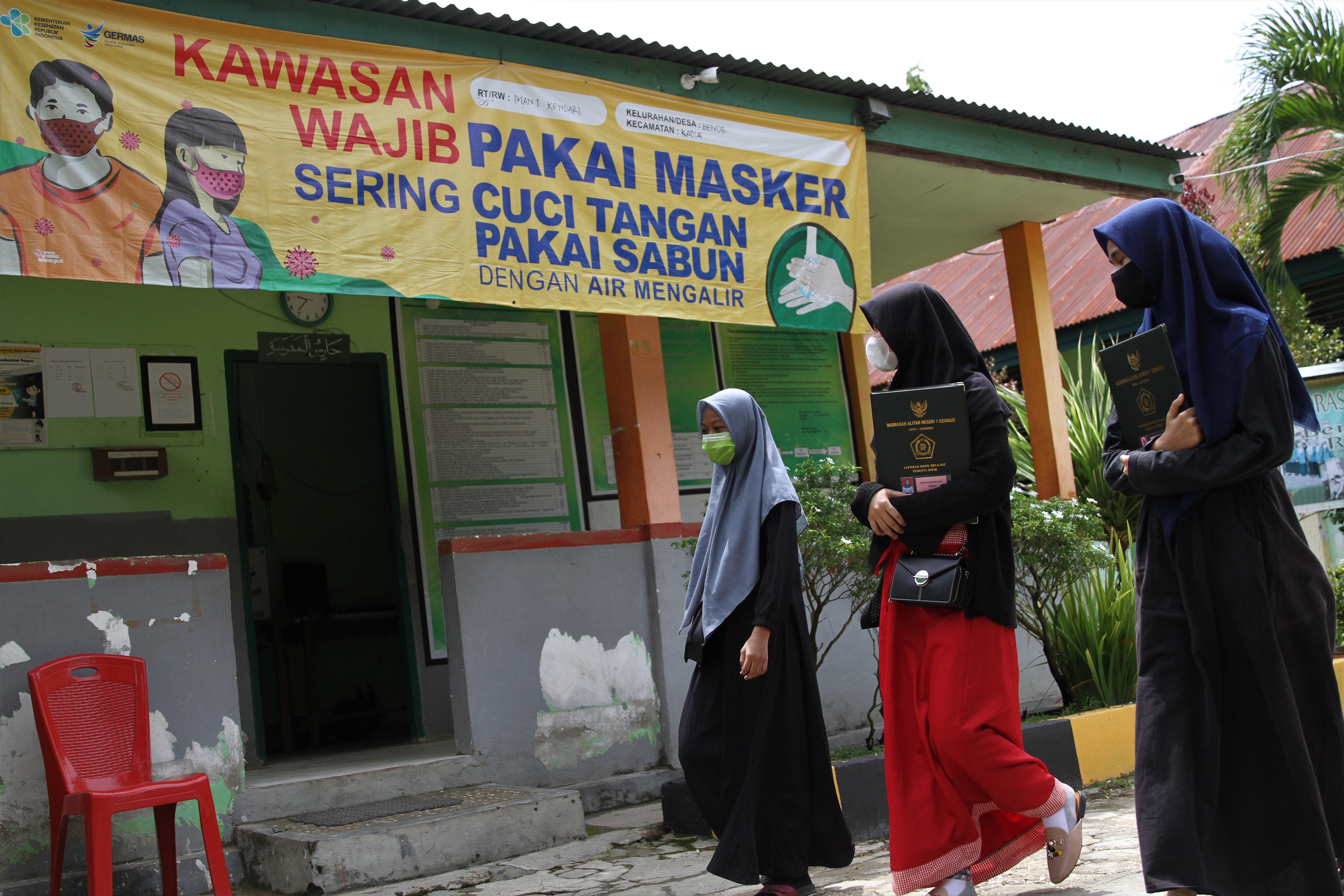  Tiga siswi berjalan masuk ke lingkungan Sekolah MAN 1 di Kendari, Sulawesi Tenggara.