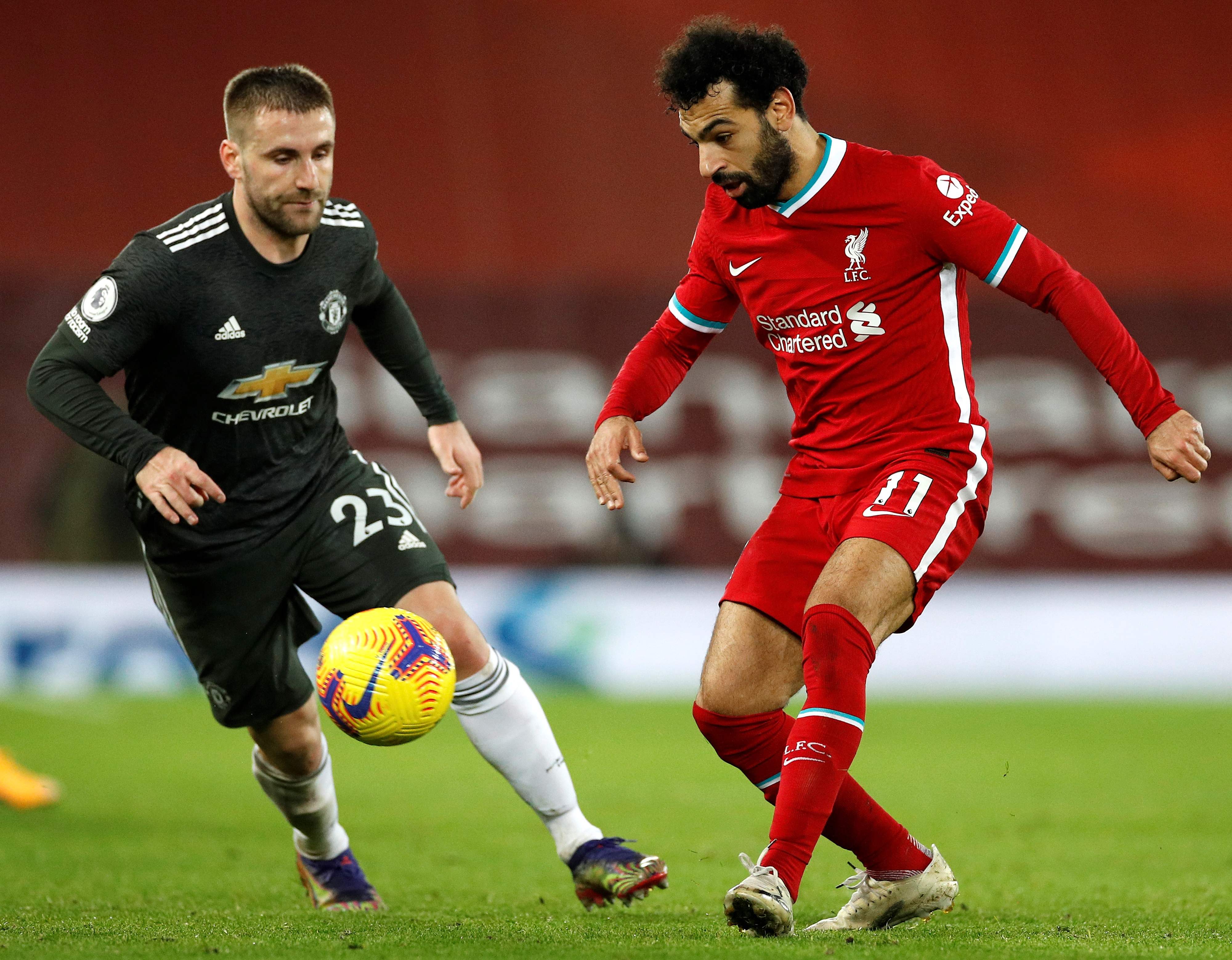 Bek Manchester United Luke Shaw (kiri) berusaha menghadang striker Liverpool Mohamed Salah dalam laga Liga Primer, Senin (18/1). 