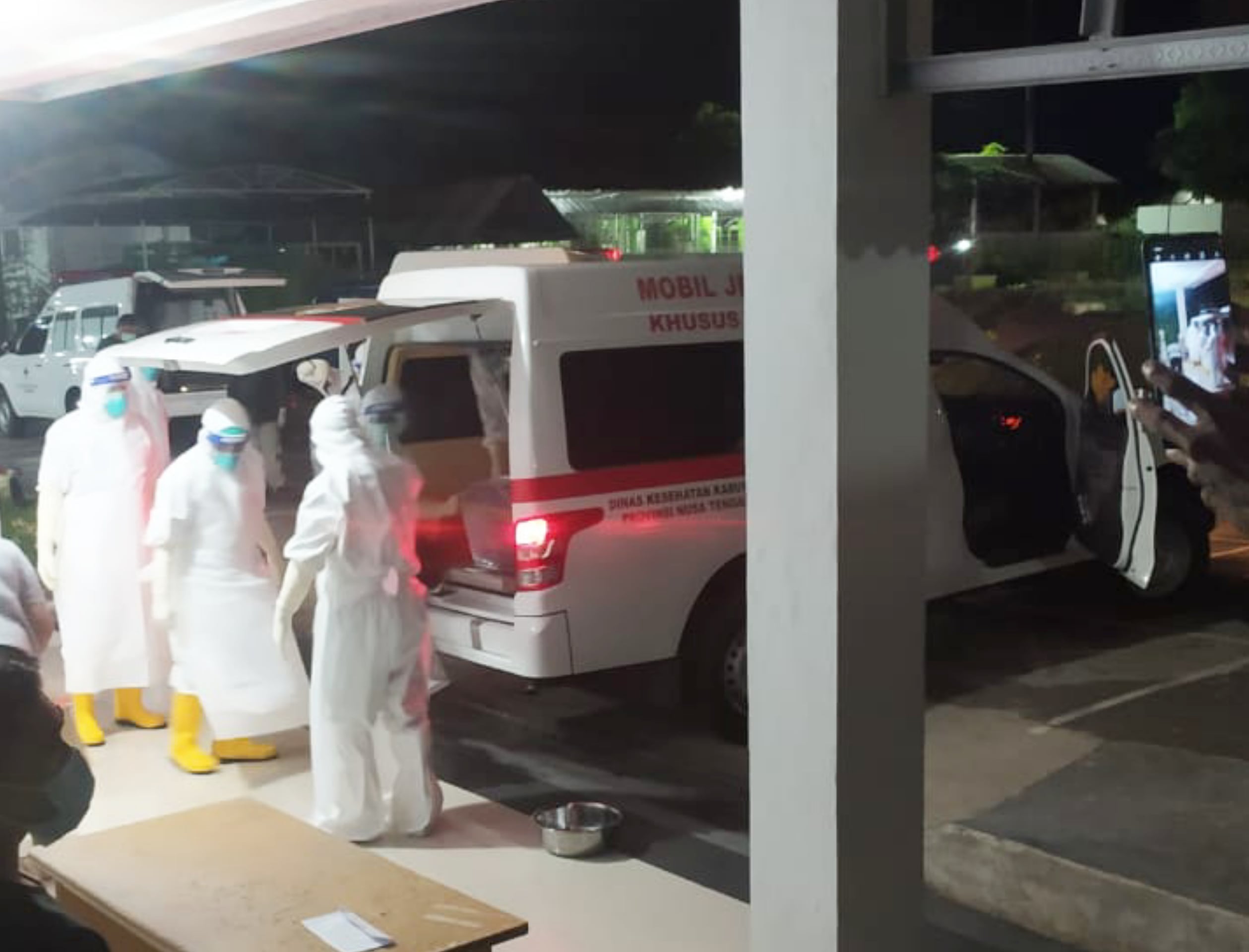 Petugas menyiapkan ambulans yang akan membawa jenazah pasien covid-19 untuk dimakamkan di Kabupaten Sikka, NTT.