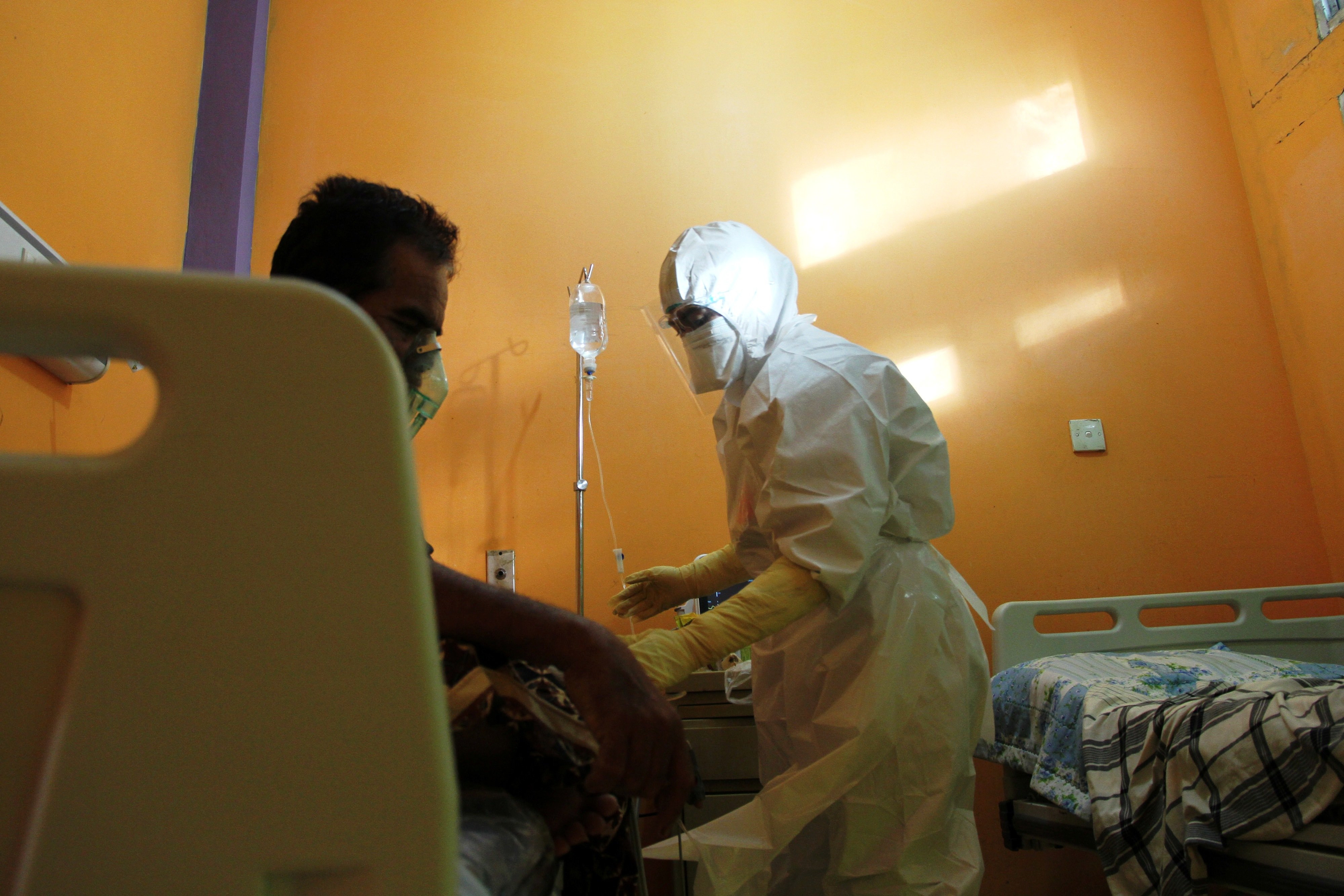 Ilustrasi seorang tenaga kesehatan (kanan) merawat pasien di ruang rawat isolasi COVID-19 di sebuah RS.