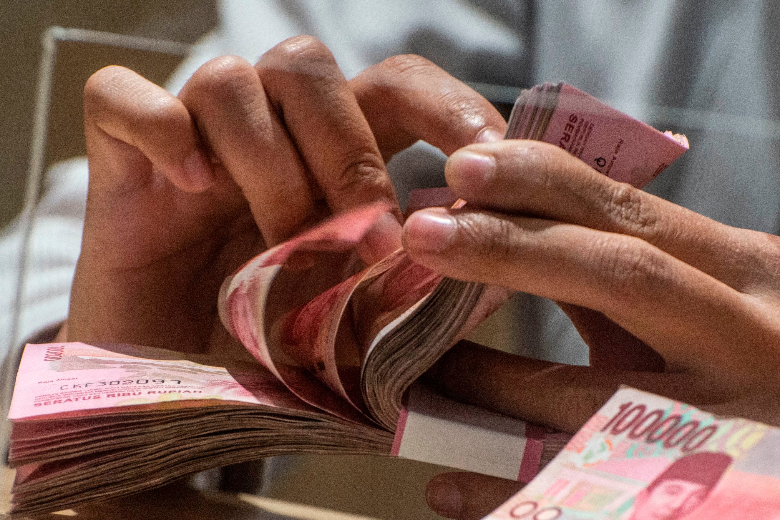 Karyawan menghitung uang rupiah di Jakarta.