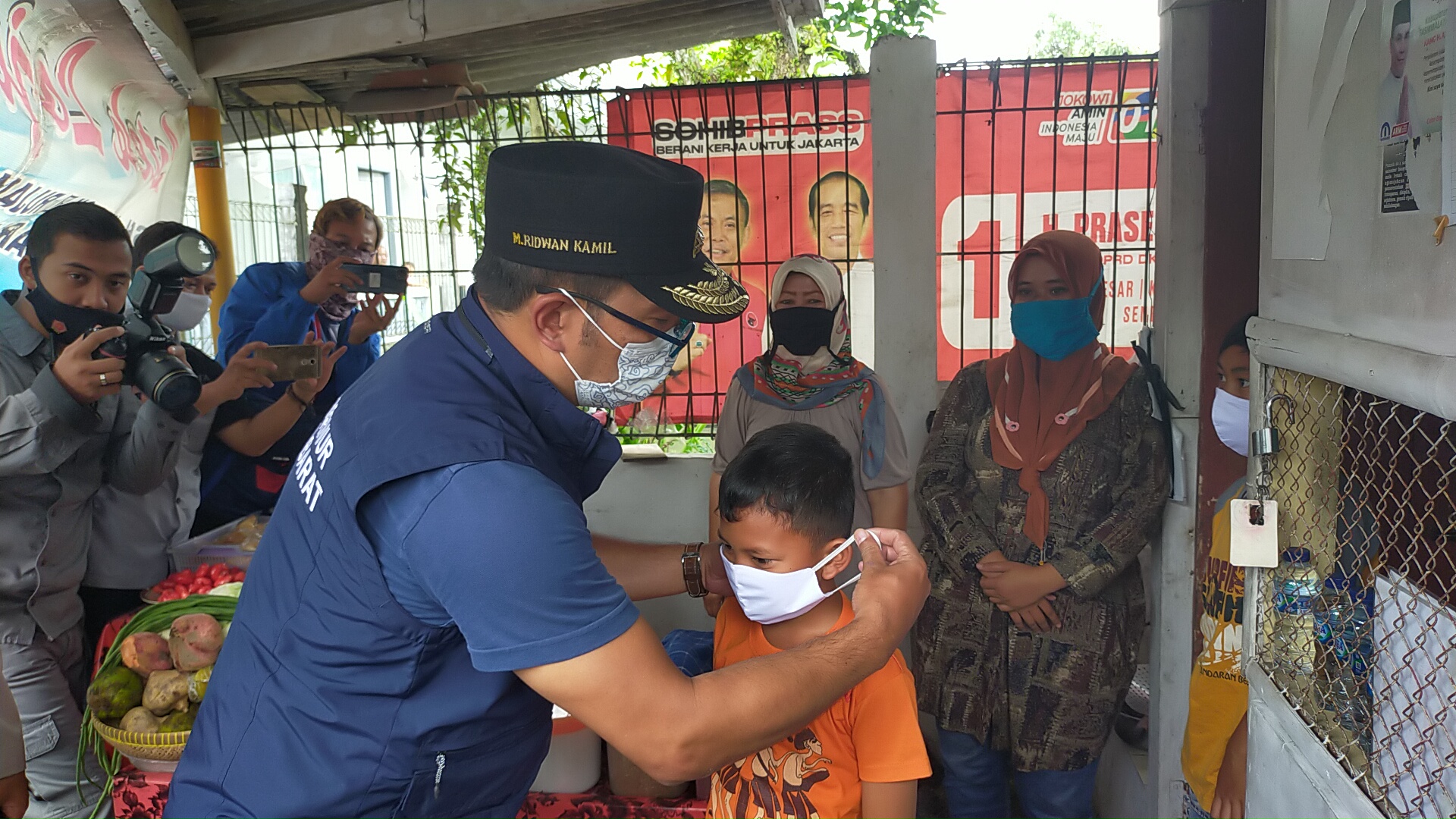 Gubernur Jabar Ridwan Kamil memakaikan masker kepada seorang anak di Alun-alun Singaparna, Tasikmalaya, Jawa Barat. 