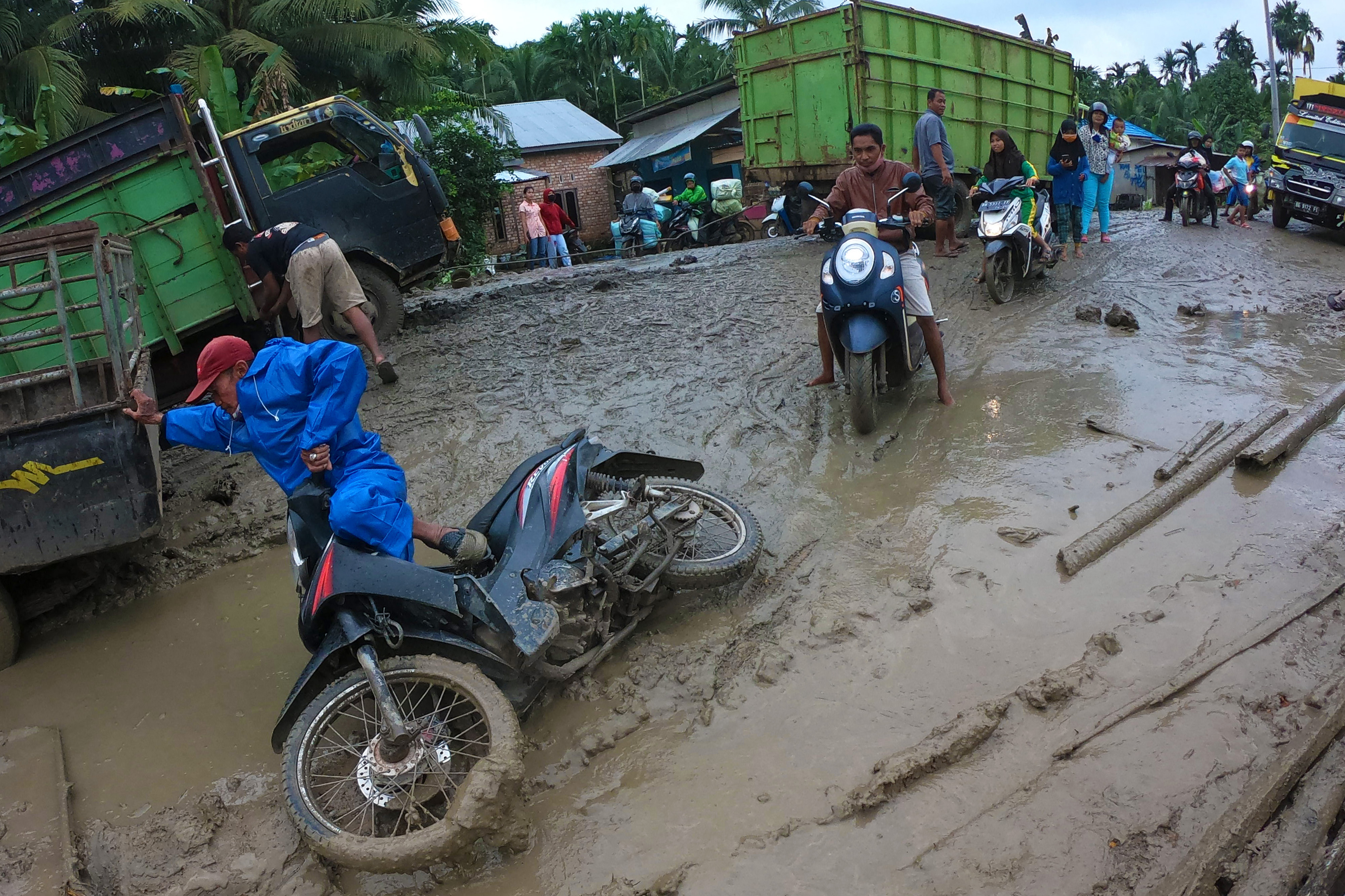Pengendara motor terjatuh saat melintasi Jalan Lintas Jambi-Nipah Panjang yang rusak di Tanjungjabung Timur, Jambi.