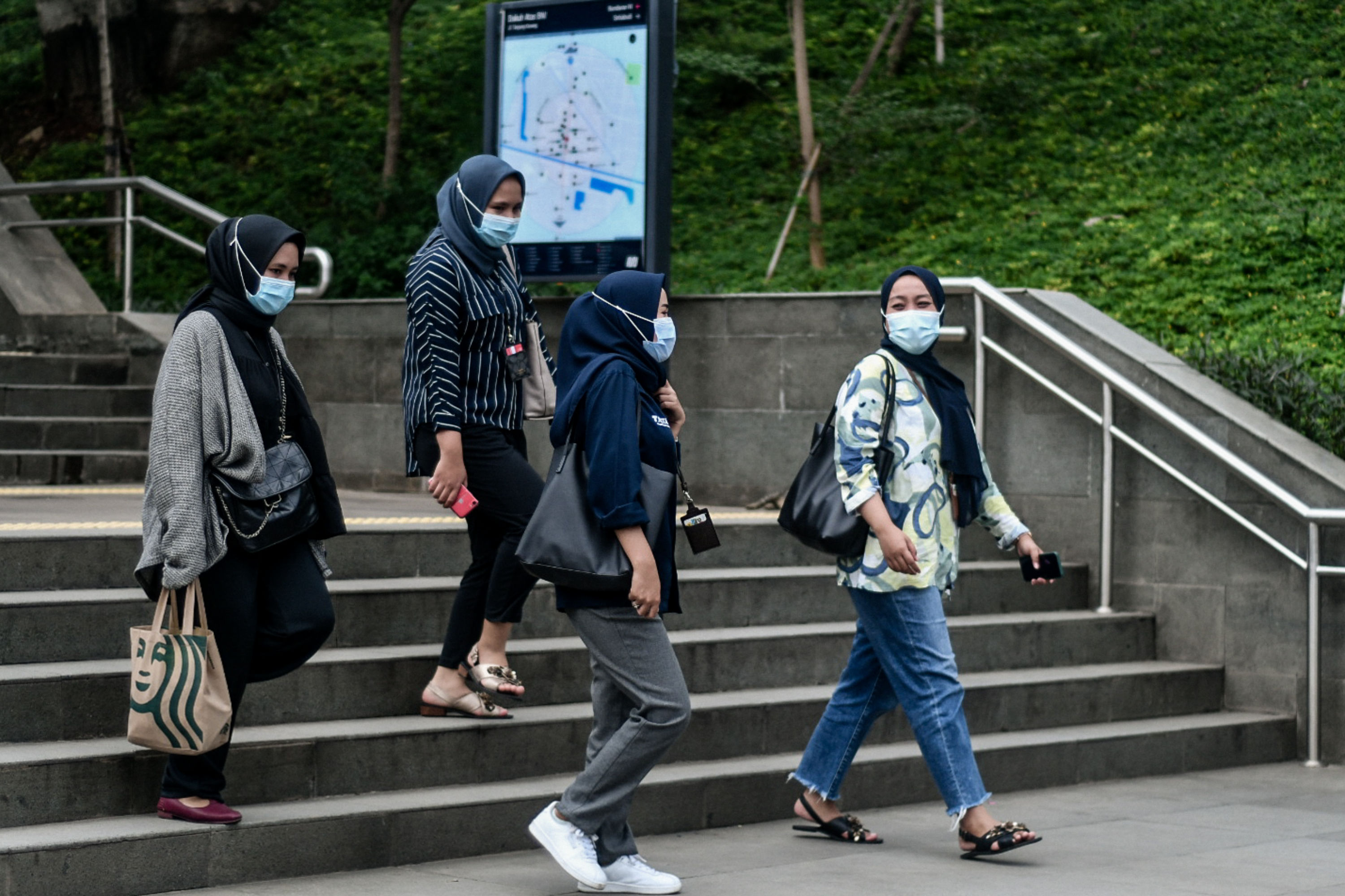 Pekerja mengenakan masker saat melintas di kawasan Dukuh Atas, Jakarta, kemarin.