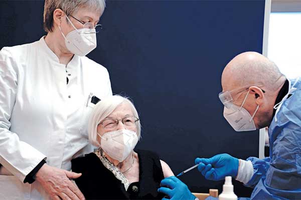 Dokter Fatmir Dalladaku (kanan) menyuntikkan vaksin covid-19 kepada manula berusia 101 tahun di Panti Jompo di Berlin.