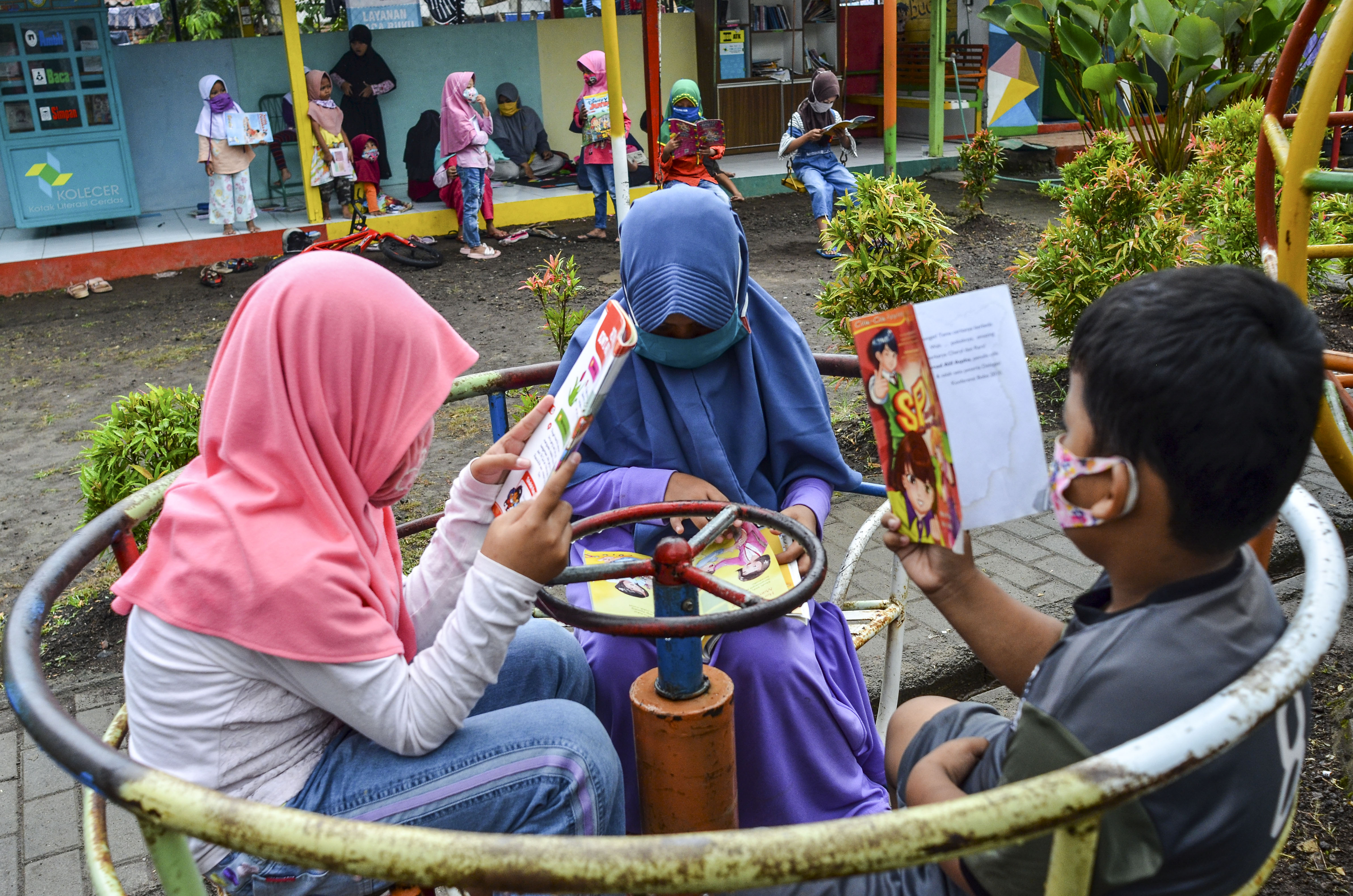 Sejumlah anak memakai masker dan membaca buku dalam mengisi waktu mereka selama pandemi covid-19.