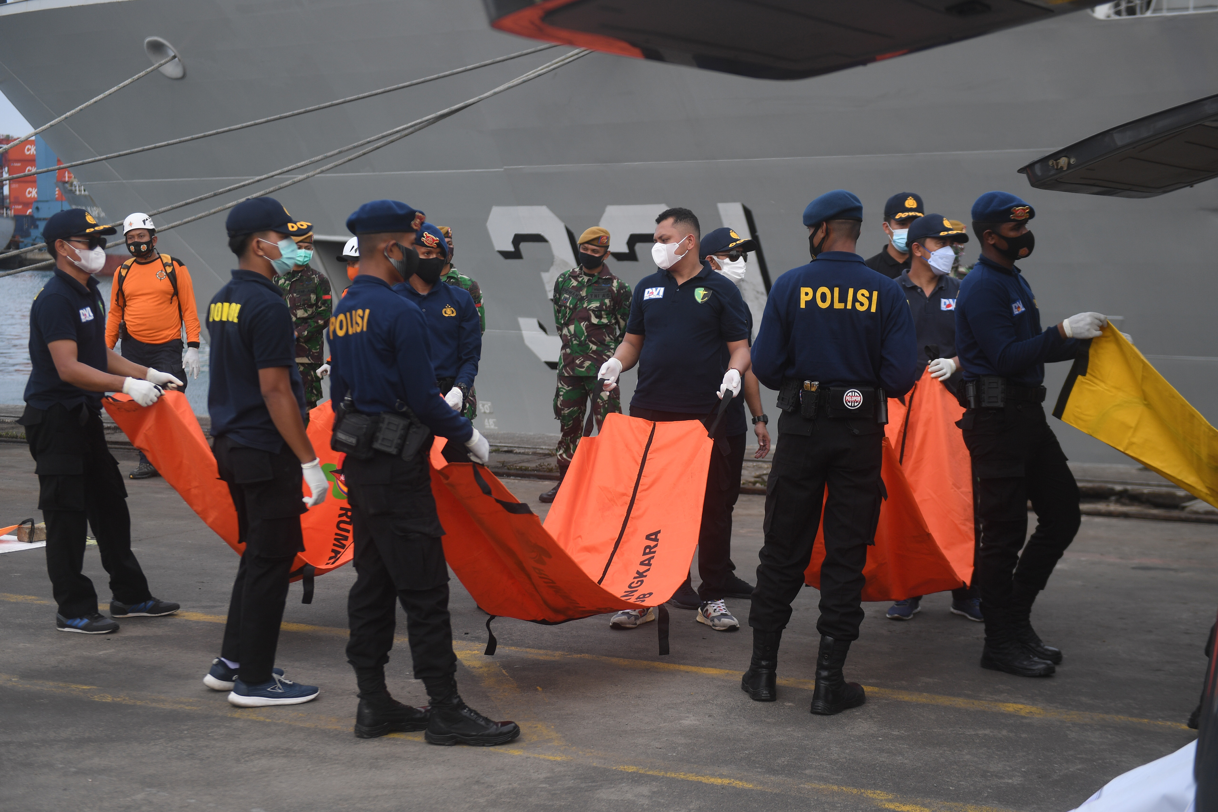 Petugas membawa kantong jenazah berisi potongan tubuh korban pesawat Sriwijaya Air SJ 182.
