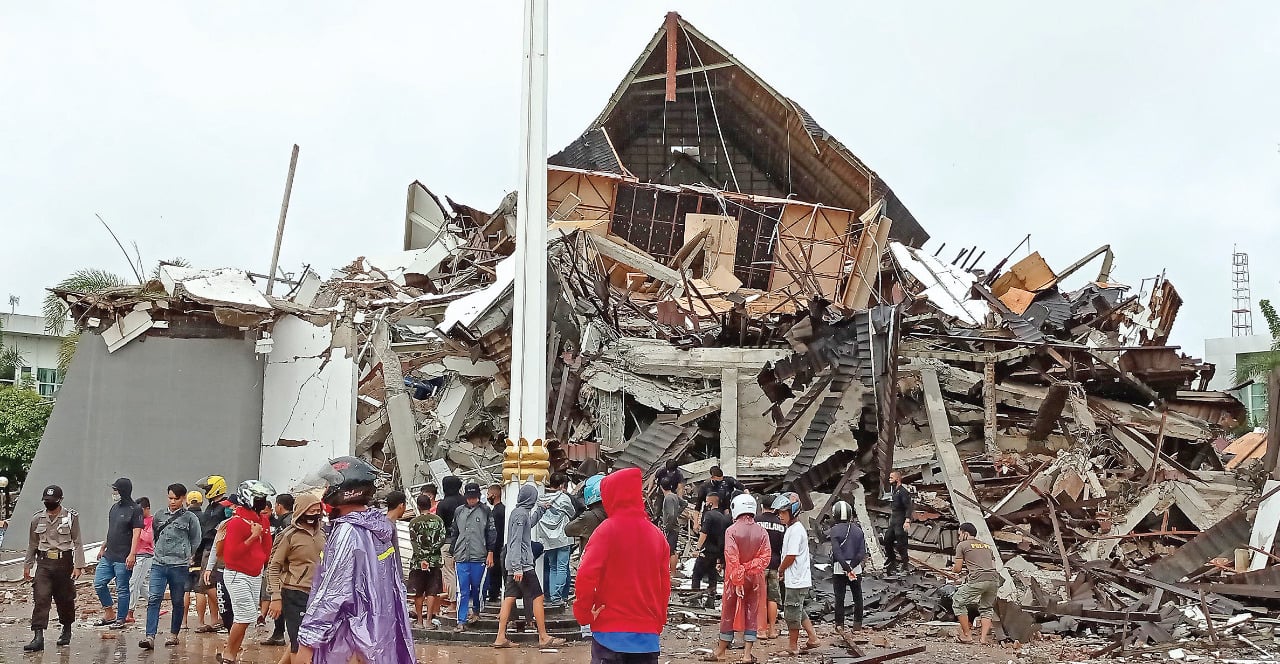 Warga melihat Kantor Gubernur Sulawesi Barat yang rusak akibat gempa di Mamuju, Sulawesi Barat, kemarin.