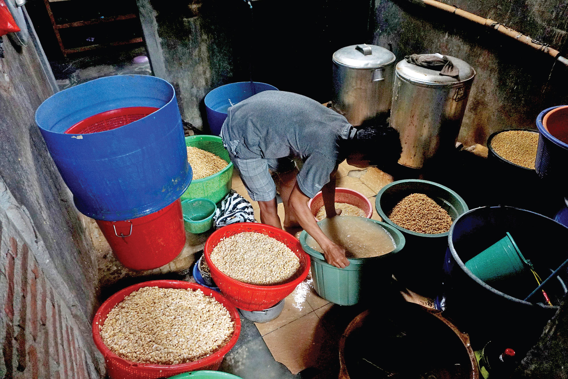 SIASAT BERTAHAN: Perajin bekerja di sentra pembuatan tempe di Desa Pliken, Kecamatan Kembaran, Banyumas, Jawa Tengah, Jumat (8/1).