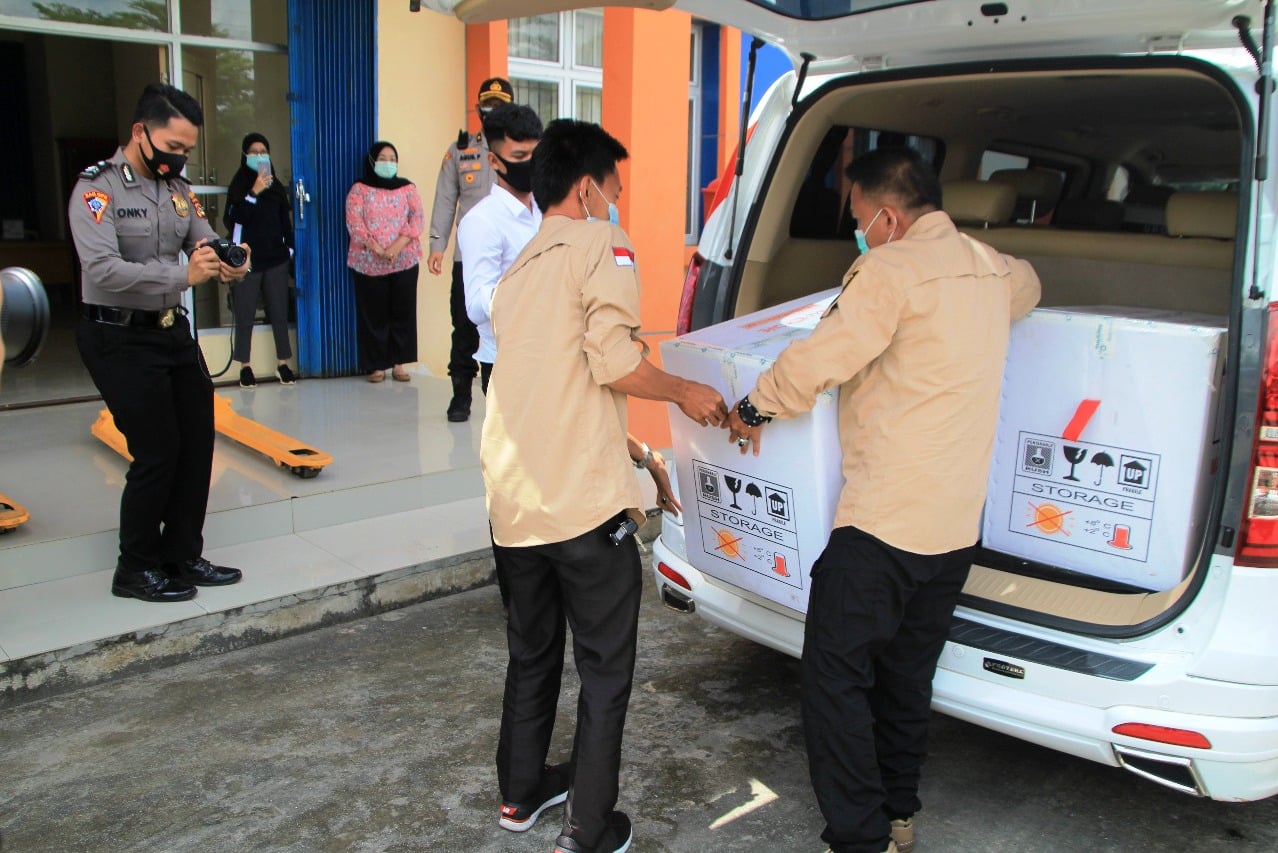 Petugas Dinkes OKI sedang memindahkan vaksin Covid-19 yang baru tiba di kabupaten tersebut. 