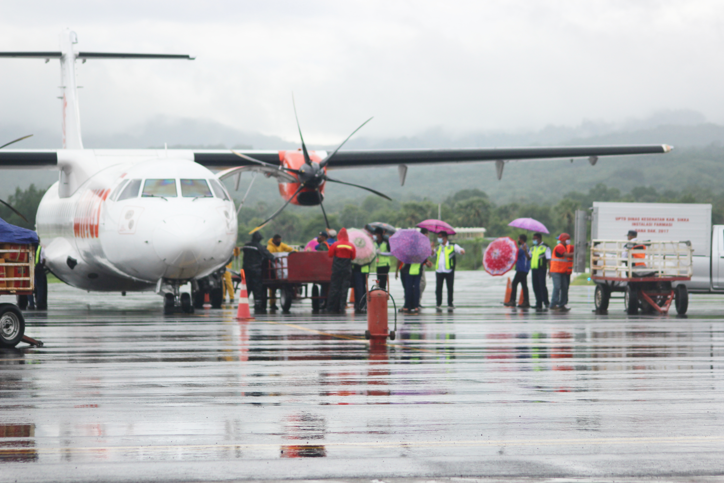 Petugas membawa keluar vaksin covid-19 dan langsung dimasukkan ke mobil boks di Bandara Frans Seda, Maumere, Sikka, Kamis (28/1/2021).