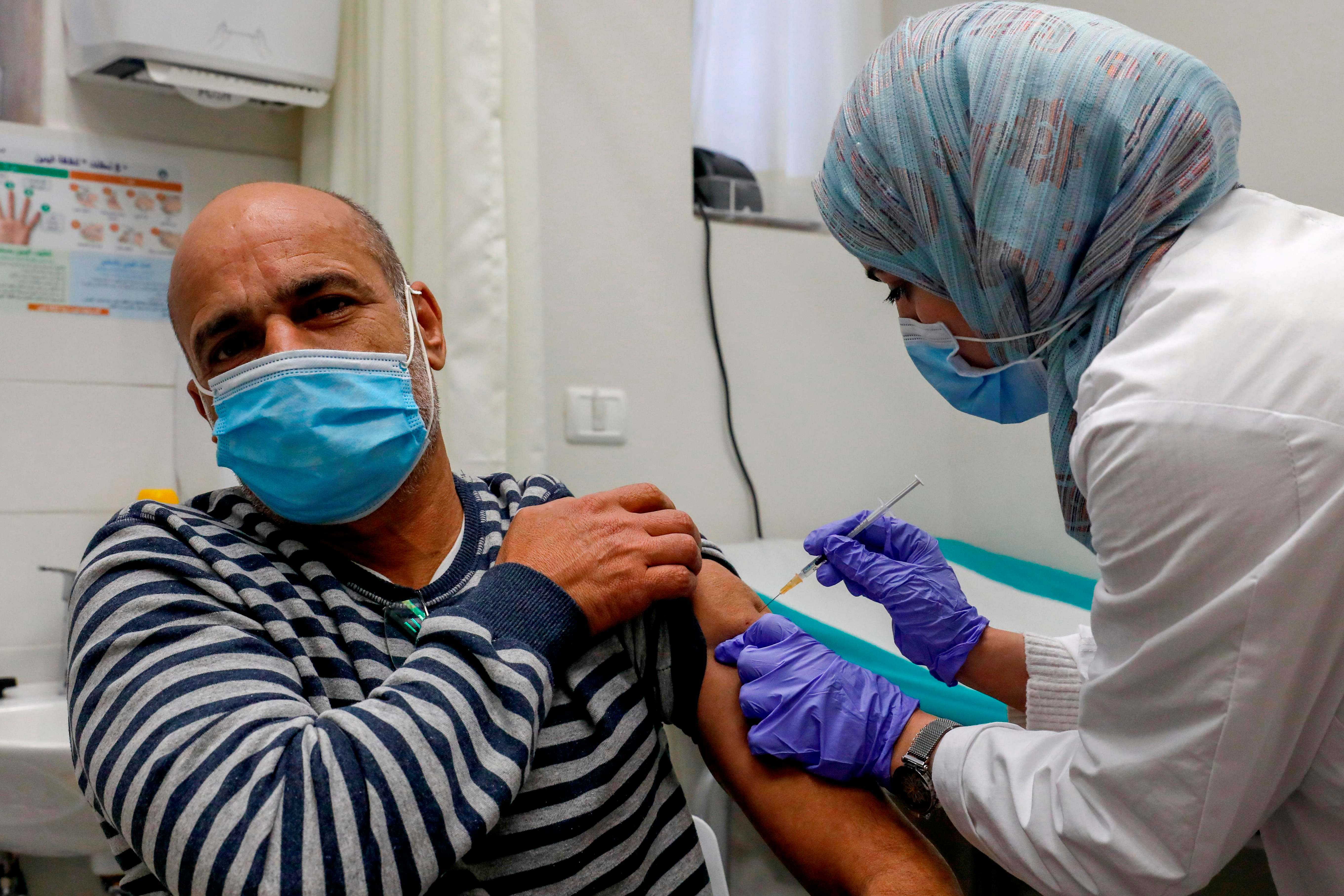 Seorang pria Palestina divaksinasi covid-19 di Layanan Kesehatan Clalit di Beit Hanina, Yerusalem timur yang dicaplok Israel.