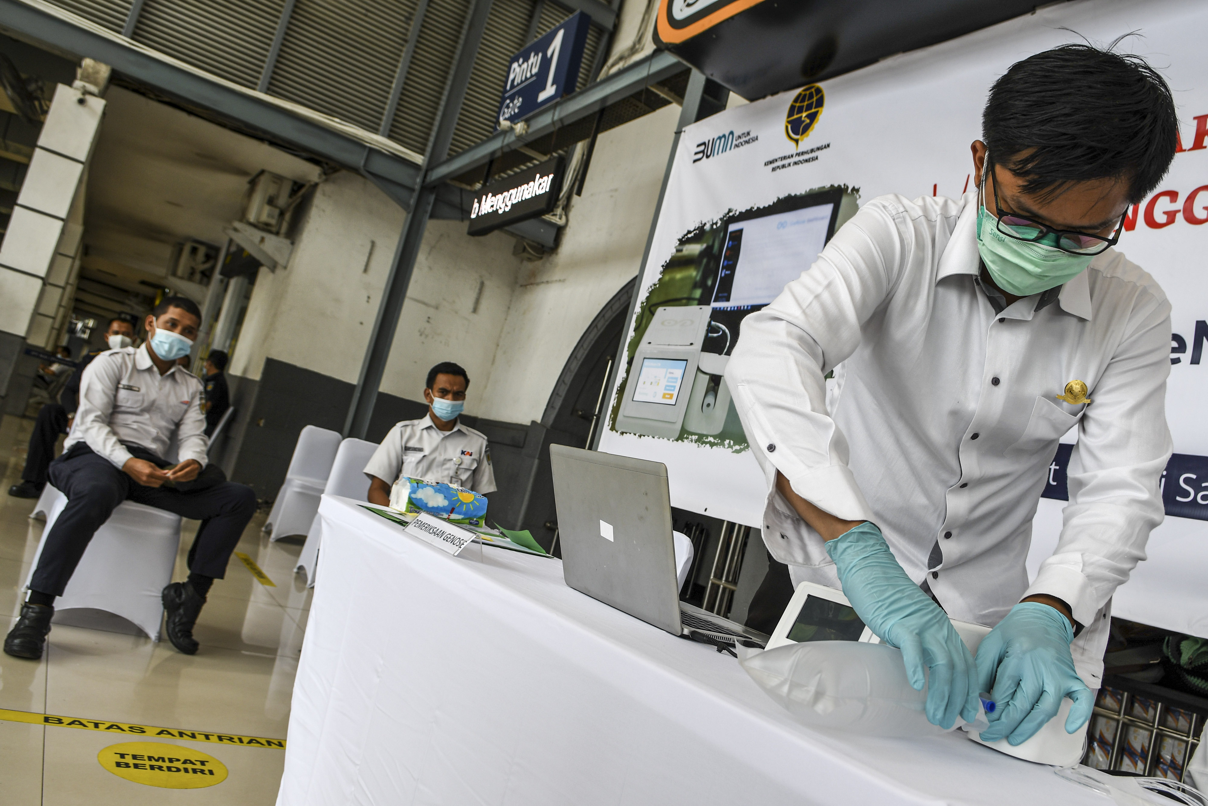 Petugas mengetes kantong nafas milik pegawai PT KAI (Persero) dengan GeNose C19 di Stasiun Pasar Senen, Jakarta, Sabtu (23/1).