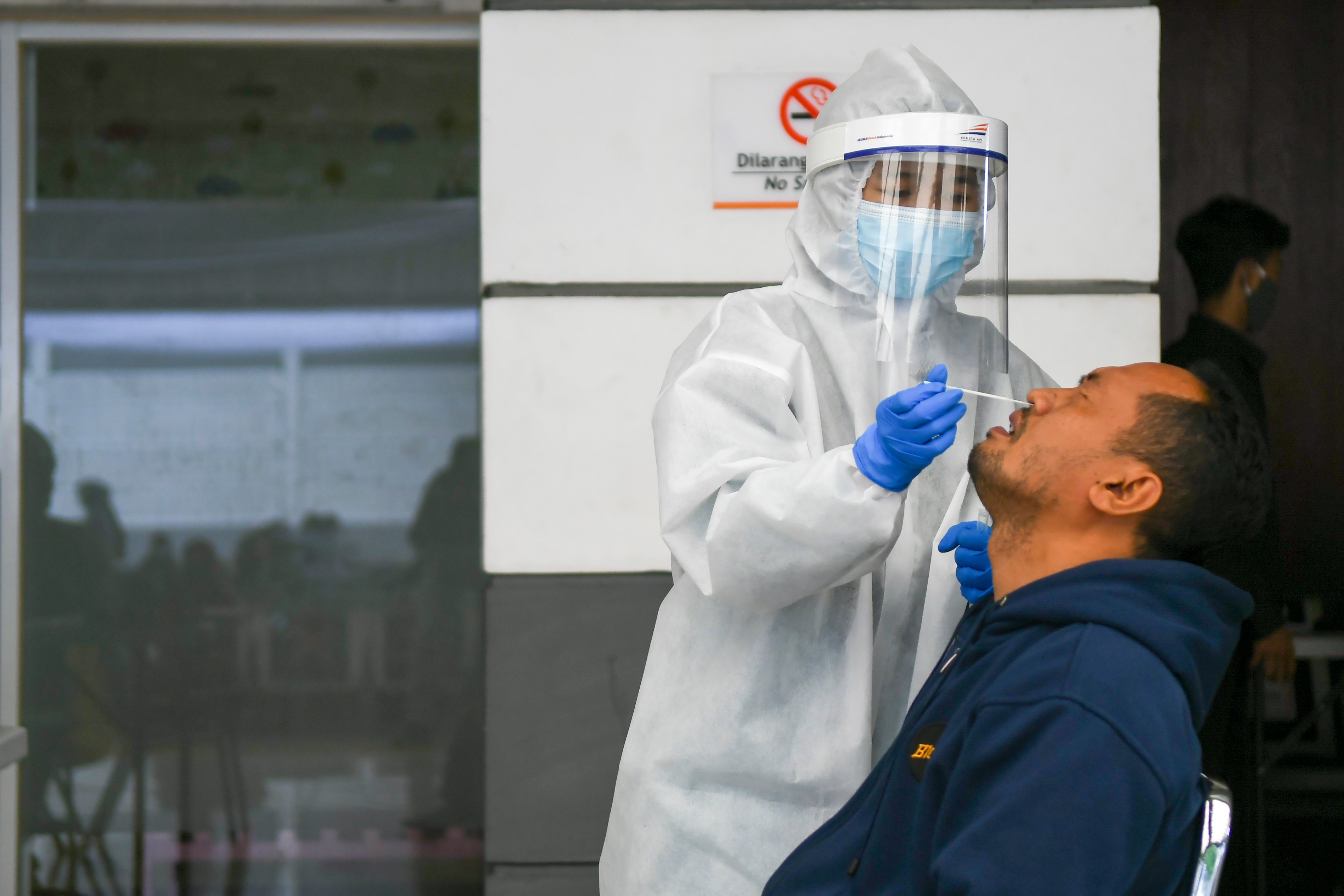 Petigas medis melakukan tes cepat antigen kepada calon penumpang KA di Stasiun Pasar Senen, Jakarta