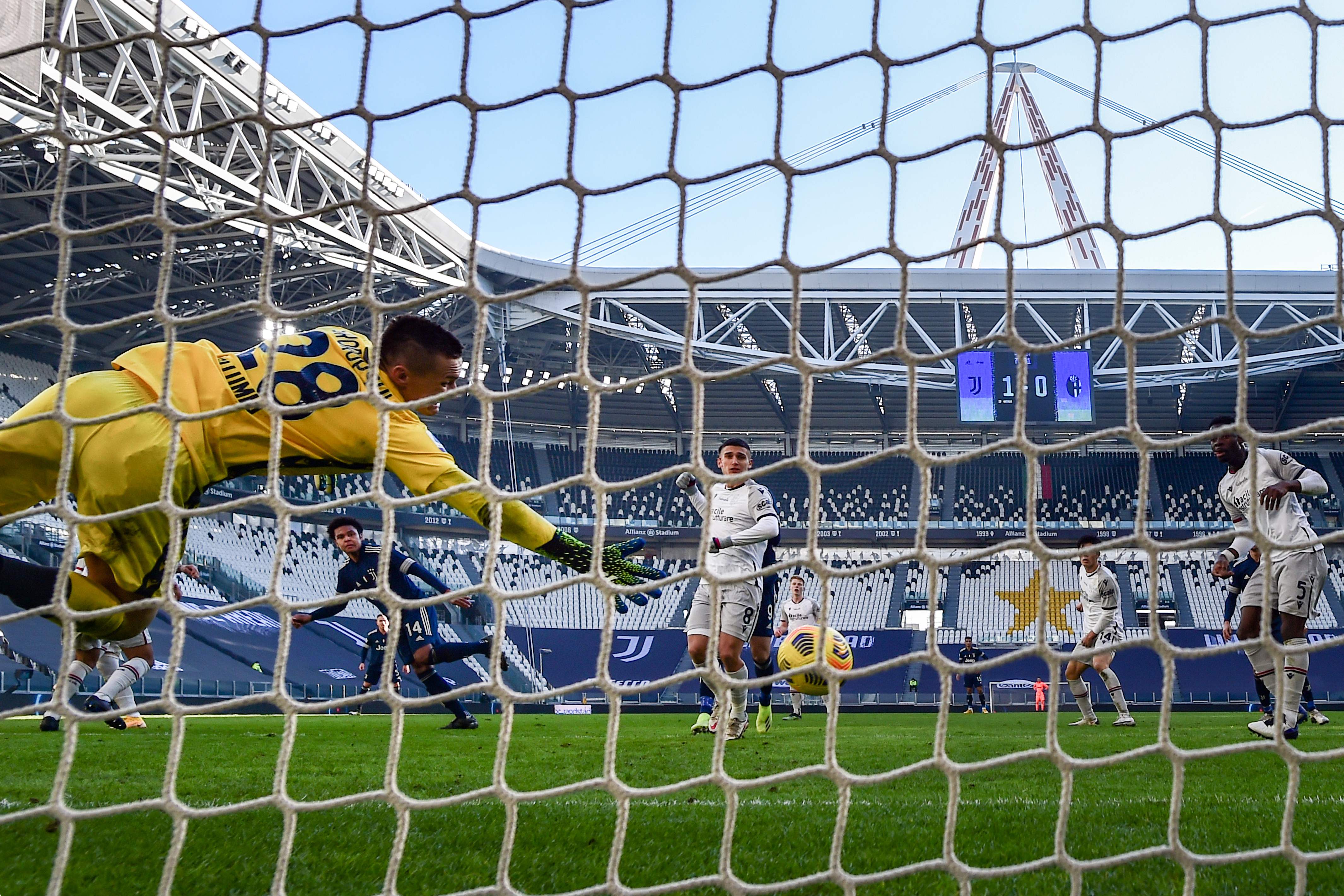 Kiper Bologna Lukasz Skorupski (kiri) tak mampu menepis bola tendangan gelandang Juventus, Weston McKennie.