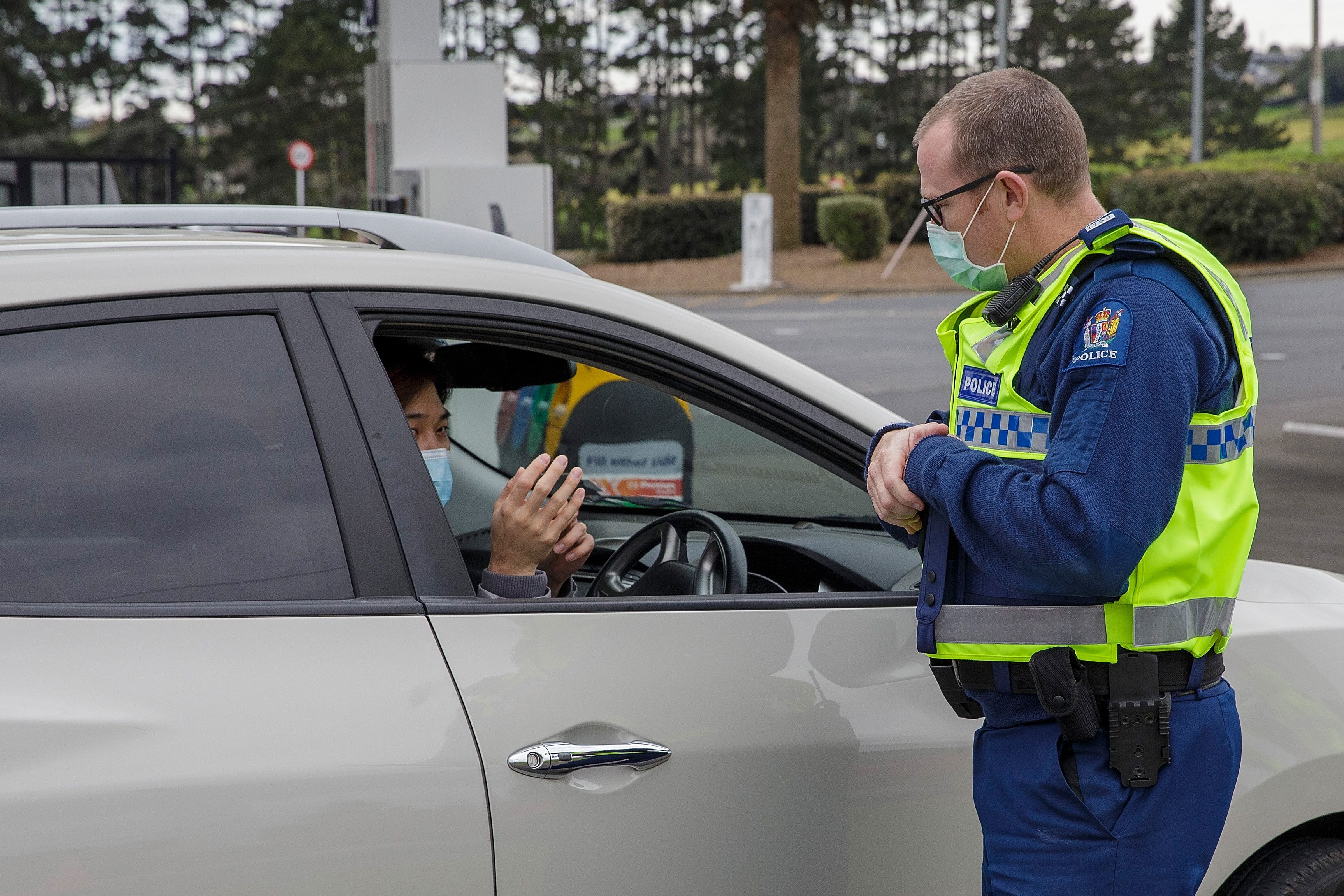 Polisi berbicara dengan warga di pos pemeriksaan covid-19 di Auckland, Selandia Baru.