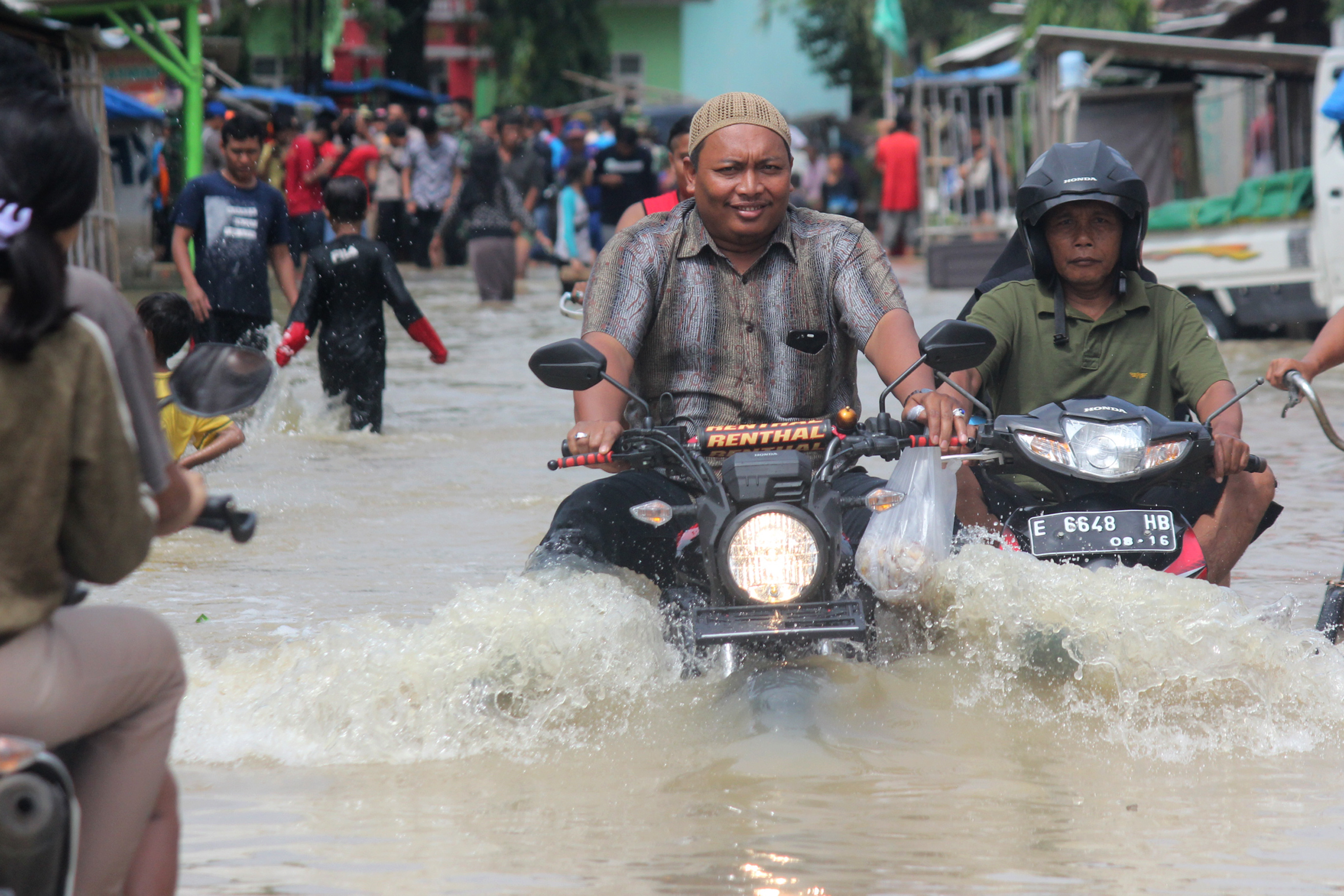  Warga melintasi genangan banjir di Desa Bojongkidul, Susukan, Kabupaten Cirebon, Jawa Barat.