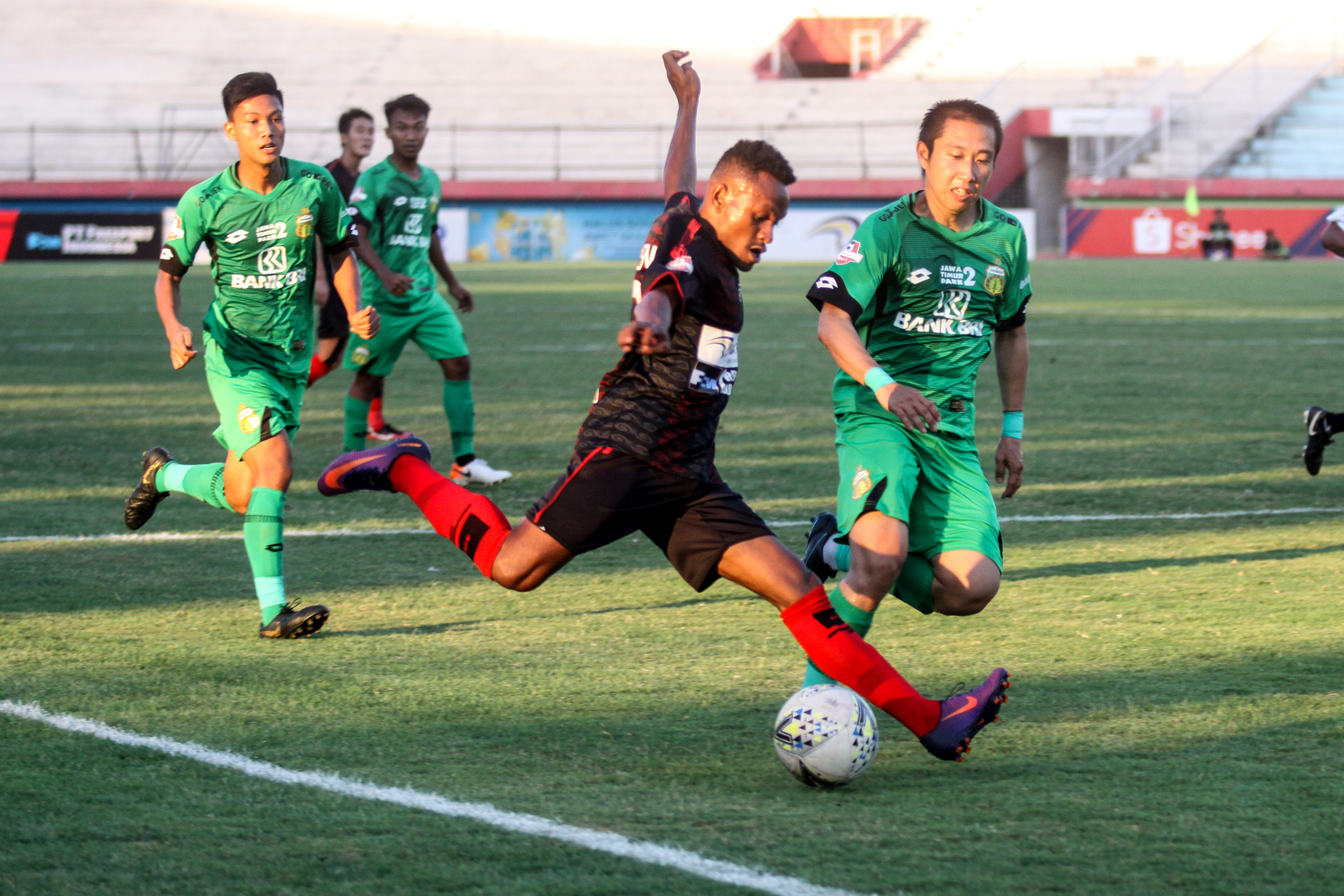Pesepak bola Persipura Jayapura Gunansar Mandoven (tengah) berusaha menendang bola saat timnya melawan Bhayangkara FC.  