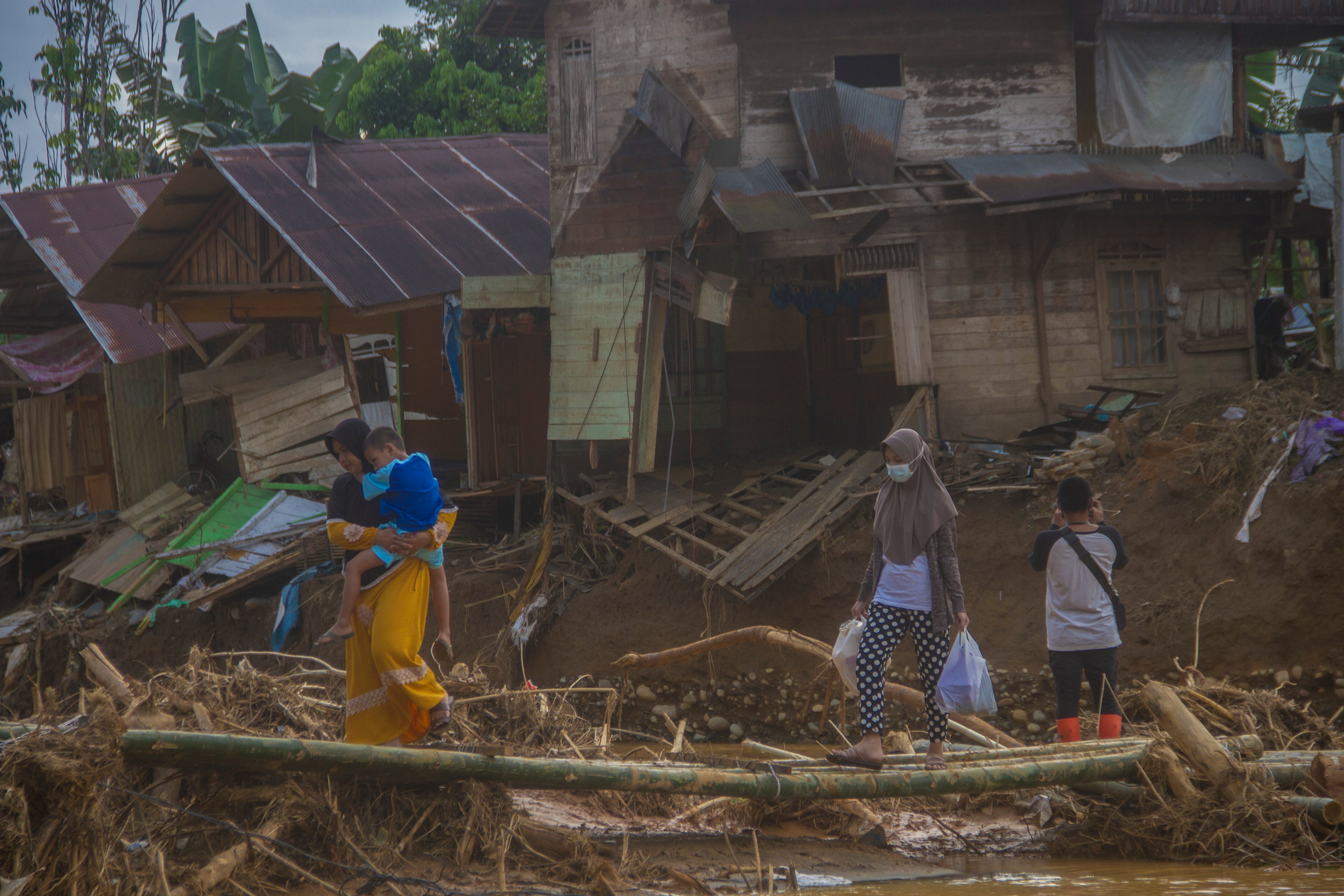  Warga menyeberang menggunakan jembatan darurat di Desa Alat putus akibat banjir bandang di Hulu Sungai Tengah, Kalsel, Rabu (20/1).