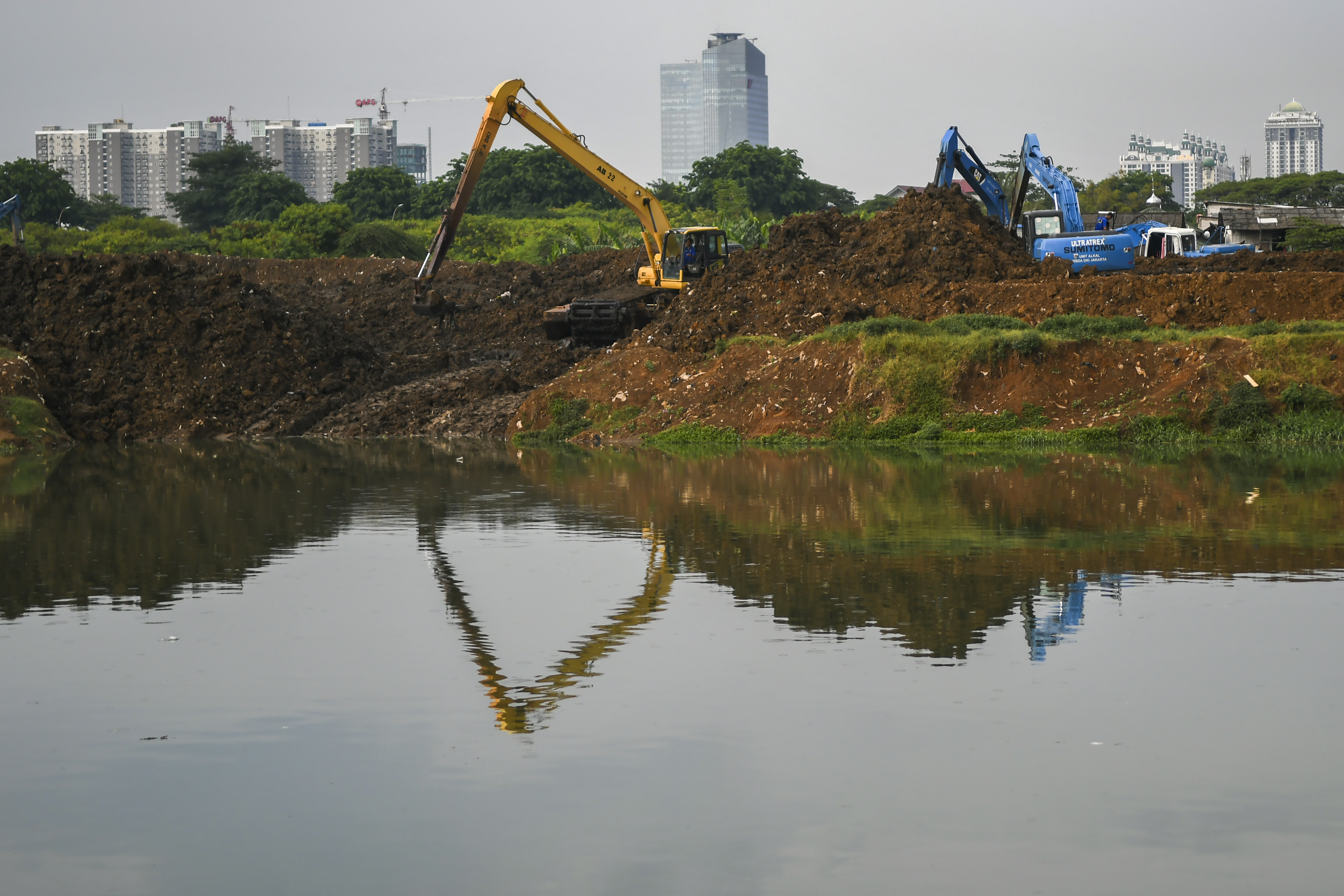 Petugas Dinas Sumber Daya Air (SDA) DKI Jakarta mengoperasikan alat berat untuk mengeruk endapan lumpur di Waduk Ria Rio, Jakarta.