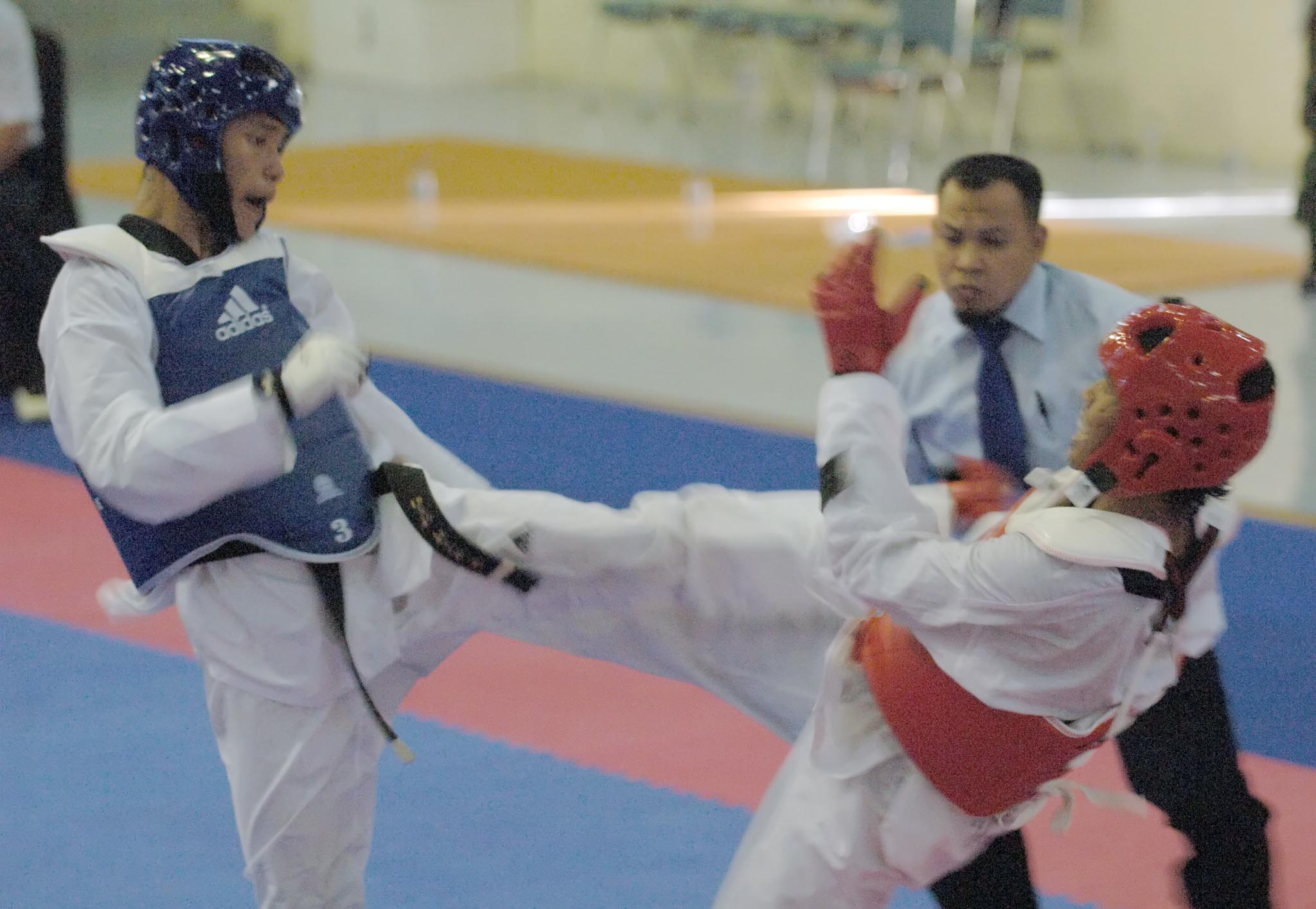 Atlit taekwondo DKI Jakarta Merry Wandra (kanan) menahan serangan lawannya Indra Darmawan dari Jateng. Merry meraih medali emas PON XVII.