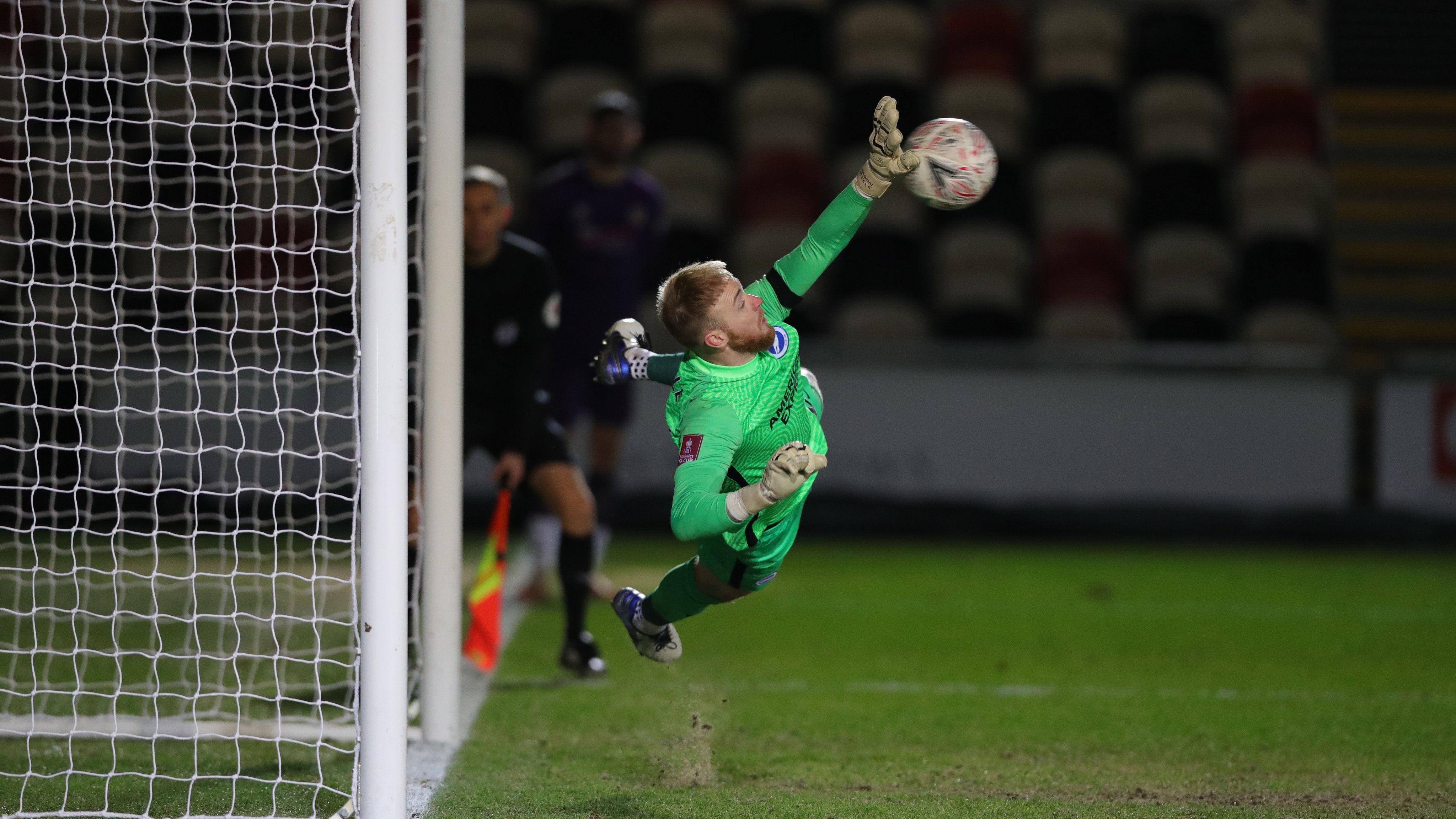 Penjaga gawang Brighton & Hove Albion Jason Steele menahan eksekusi penalti pemain Newport County di laga Piala FA.