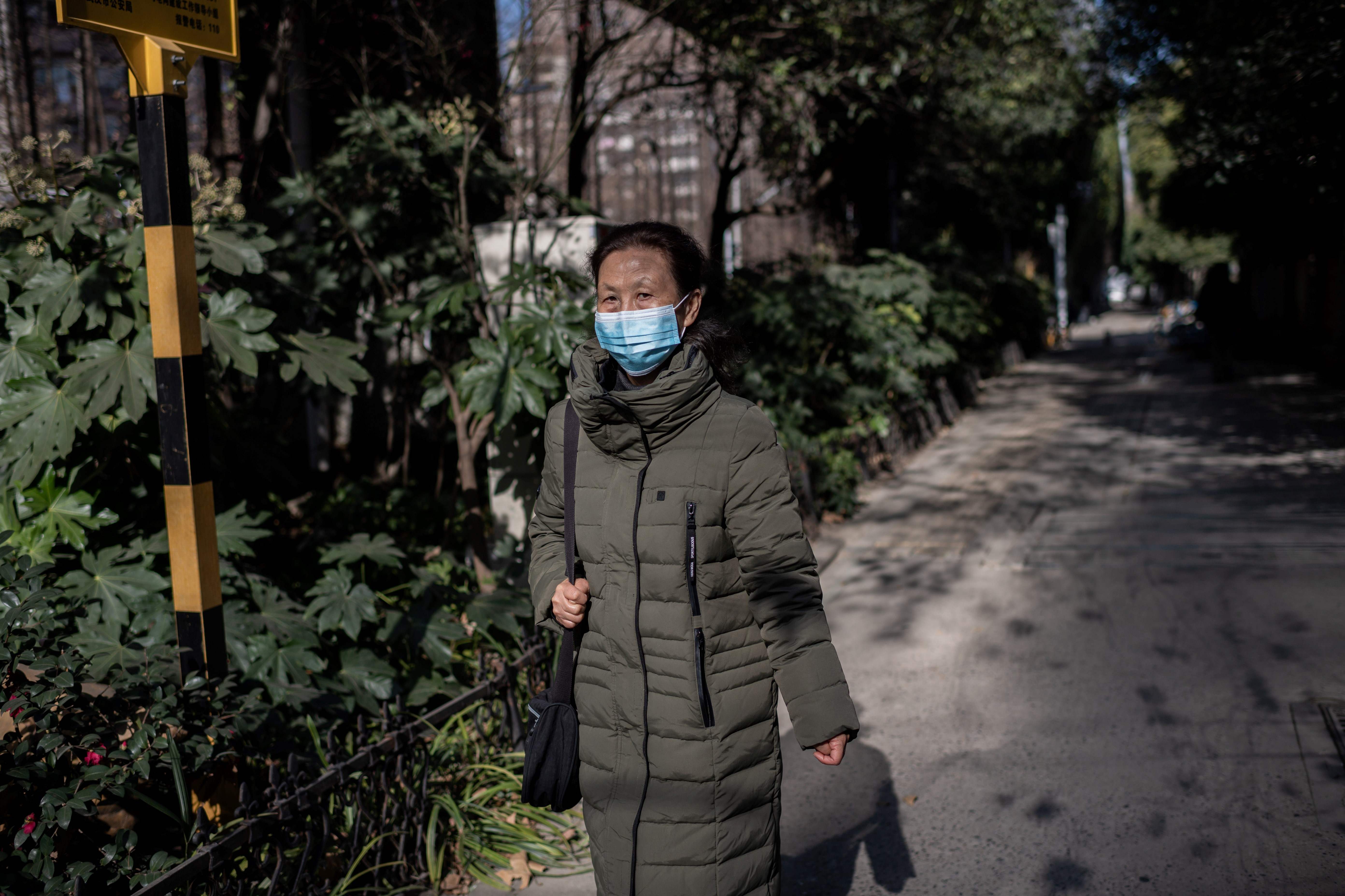 Warga berjalan mengenakan masker di Kota Wuhan, Provinsi Hubei, Tiongkok yang menjadi sumber awal Covid-19.