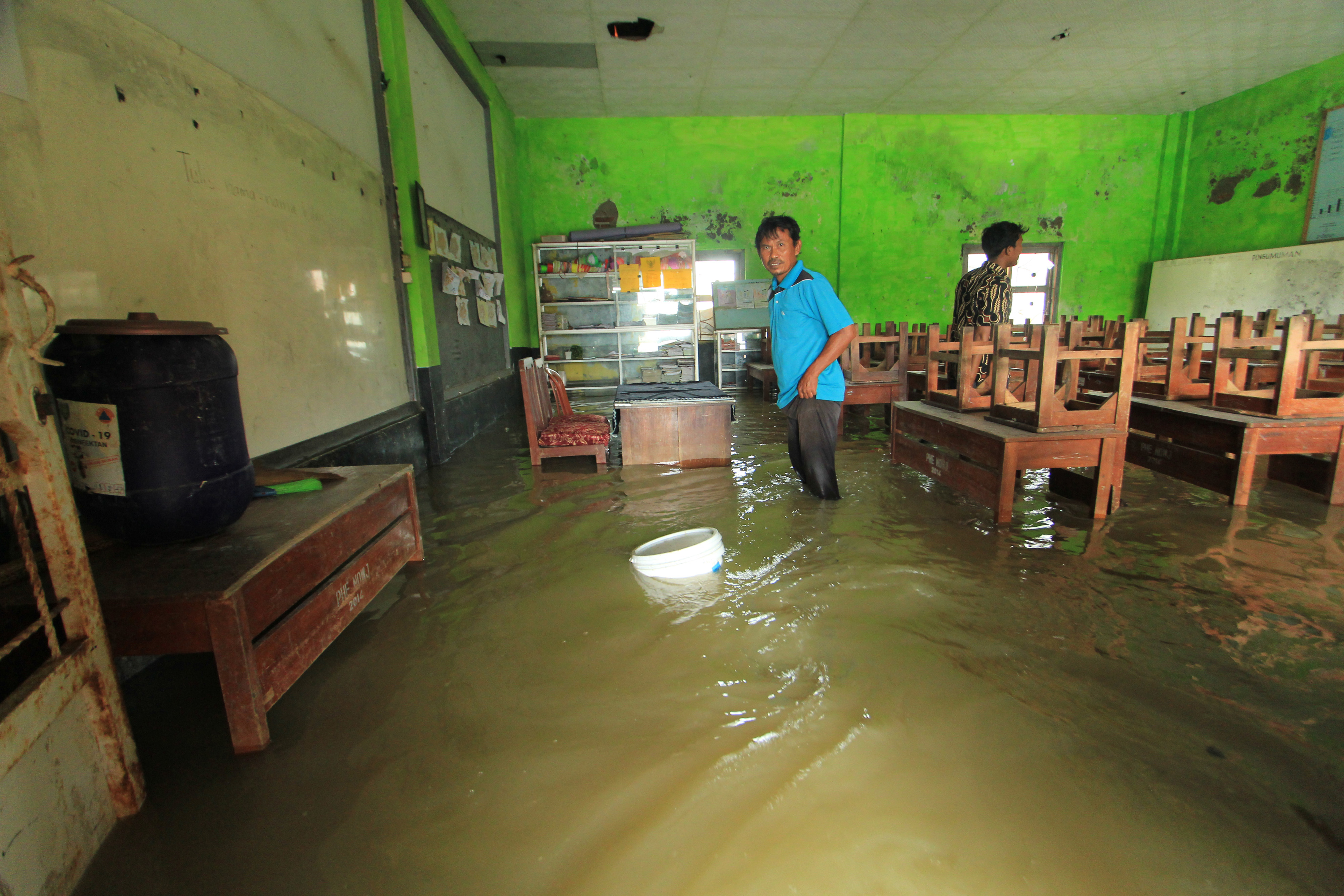 Guru menyelamatkan inventaris sekolah di ruangan kelas yang terendam banjir rob di SDN Eretan Wetan, Kandanghaur, Indramayu, Jabar, kemarin.