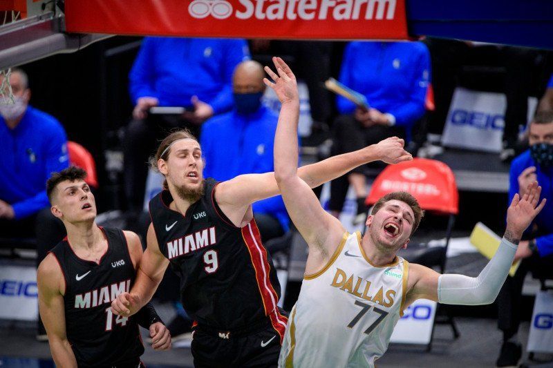 Guard Dallas Mavericks Luka Doncic (77) dan forward Miami Heat Kelly Olynyk (9) berebut bola dalam pertandingan NBA, Jumat (1/1).