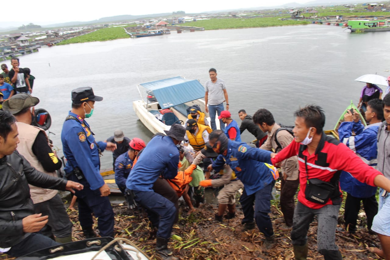 Petugas mengevakuasi korban tewas dalam peristiwa perahu terbaik di Waduk Cirata, Purwakarta, Jawa Barat, Jumat (1/1).    