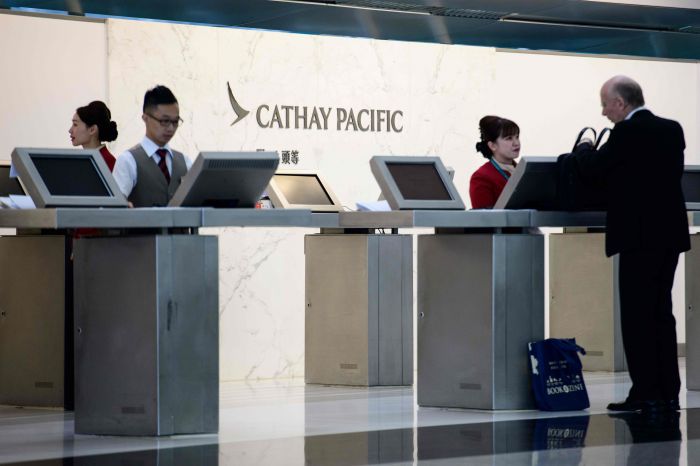 Para petugas Cathay Pacific melayani calon penumpang di Bandara Hong Kong.