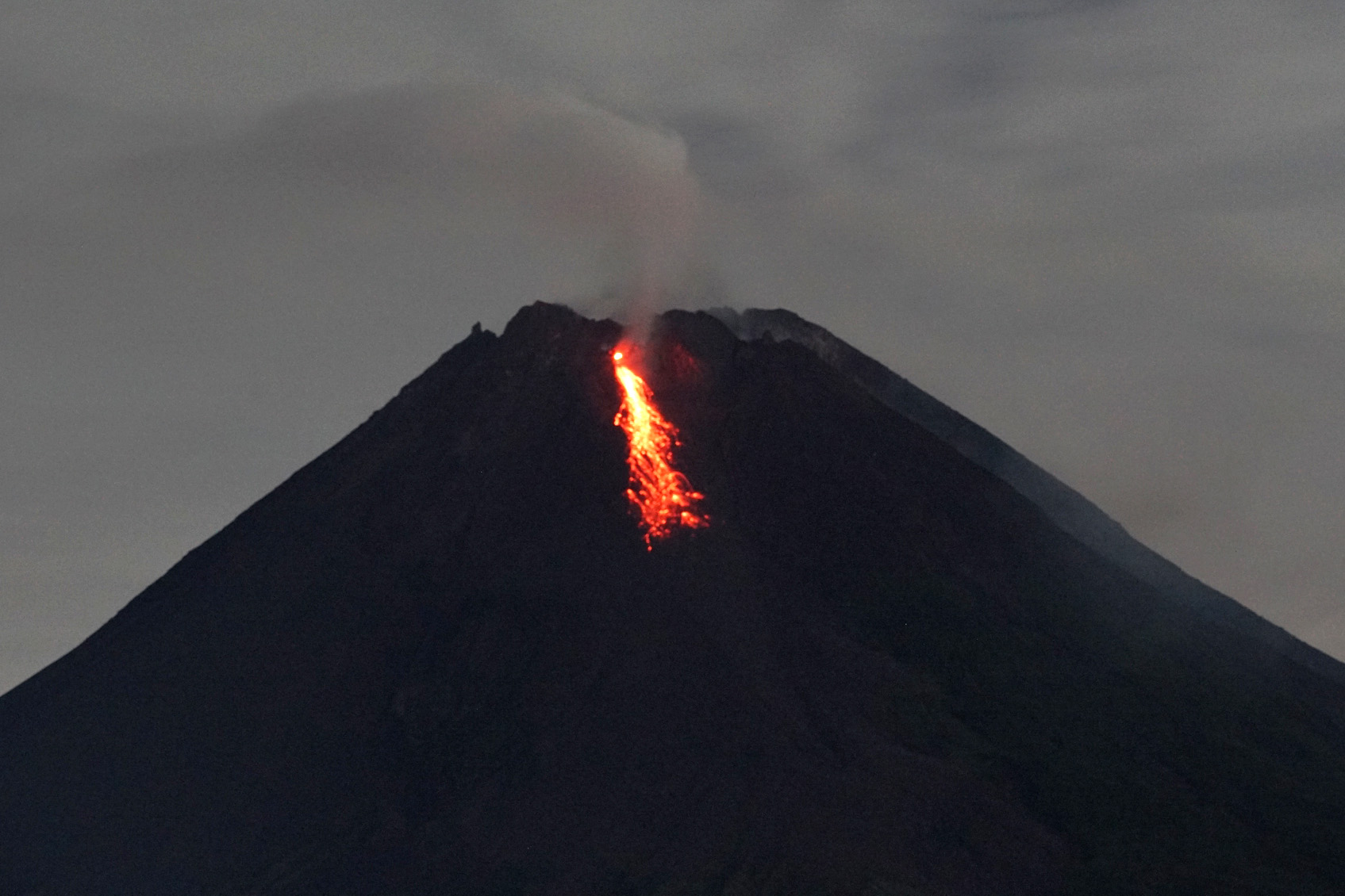 Gunung Merapi mengeluarkan lava pijar yang terlihat dari Tunggularum, Wonokerto, Turi, Sleman, Kamis (7/1)