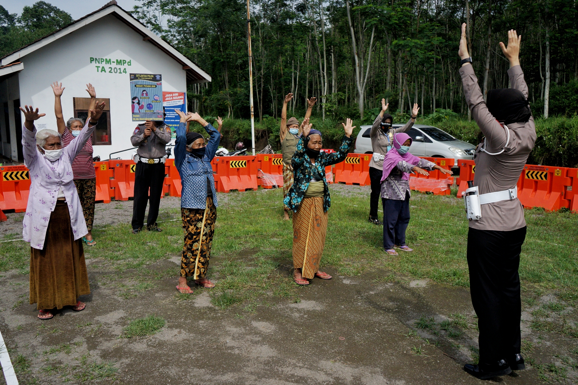 Polisi memandu gerakan senam untuk pengungsi lereng Gunung Merapi di Barak Pengungsian Glagaharjo, Cangkringan, Sleman, D.I Yogyakarta.
