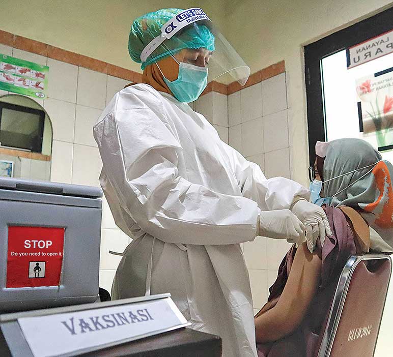 Petugas kesehatan memberikan contoh cara memvaksin seorang pasien saat simulasi pemberian vaksin covid-19 Sinovac  
