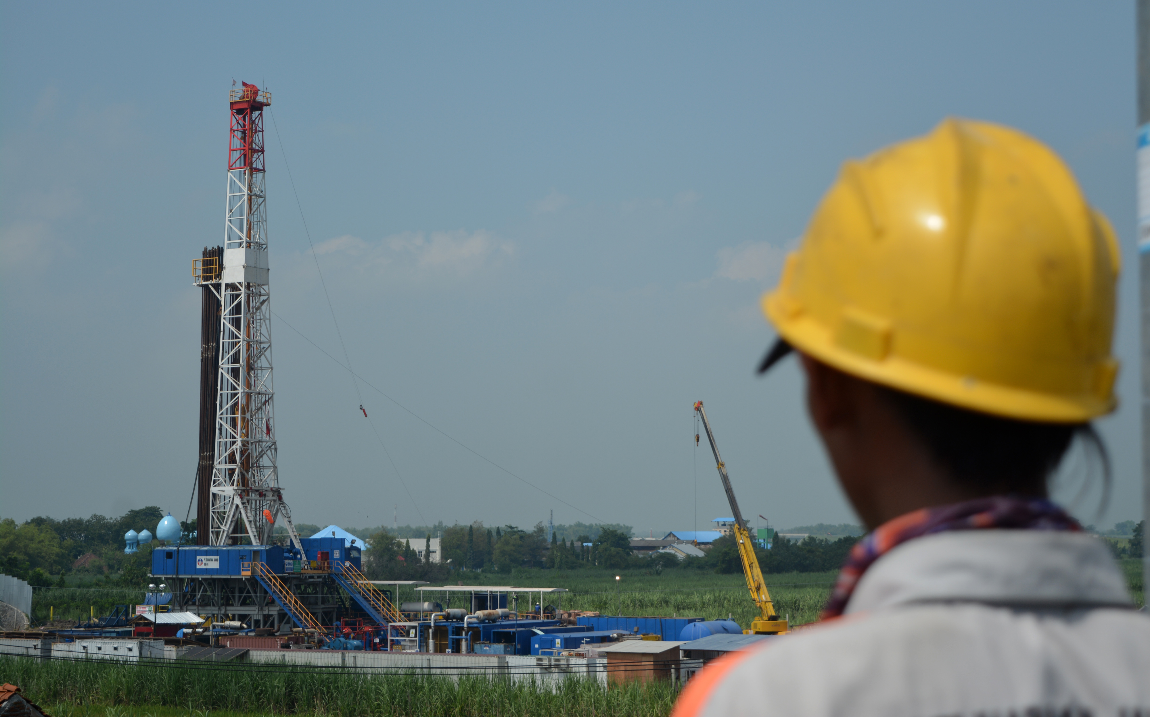 Pekerja sedang memperhatikan pekerjaan di blok migas.
