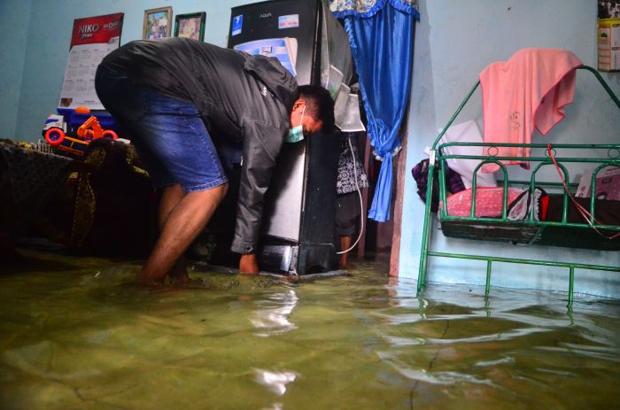 Warga menyelamatkan barang di rumah yang terendam banjir di Desa Jati Wetan, Kudus, Jawa Tengah.