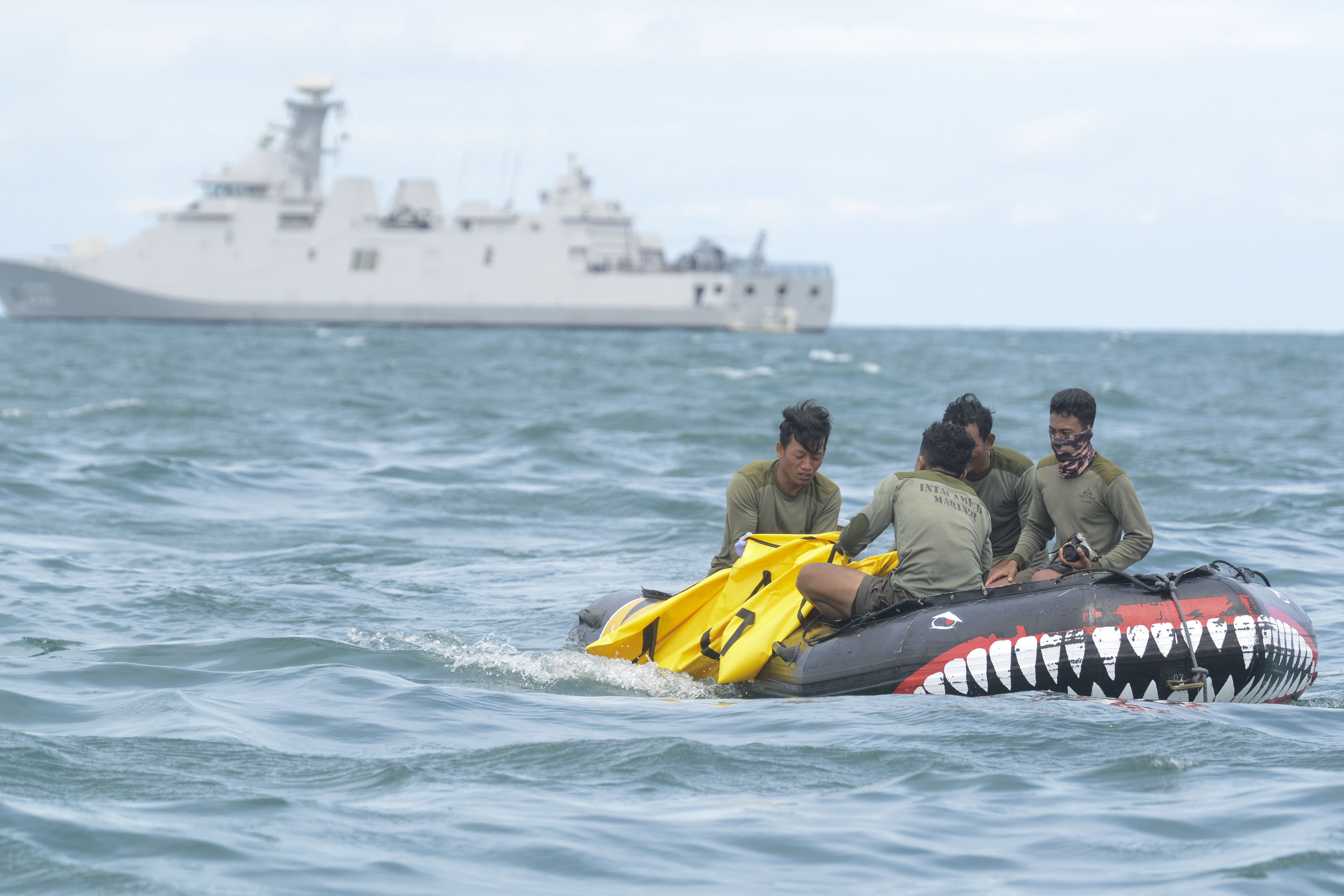 Prajurit Korps Marinir TNI AL memasukkan puing pesawat Sriwijaya Air di perairan Kepulauan Seribu, Jakarta, Selasa (12/1).