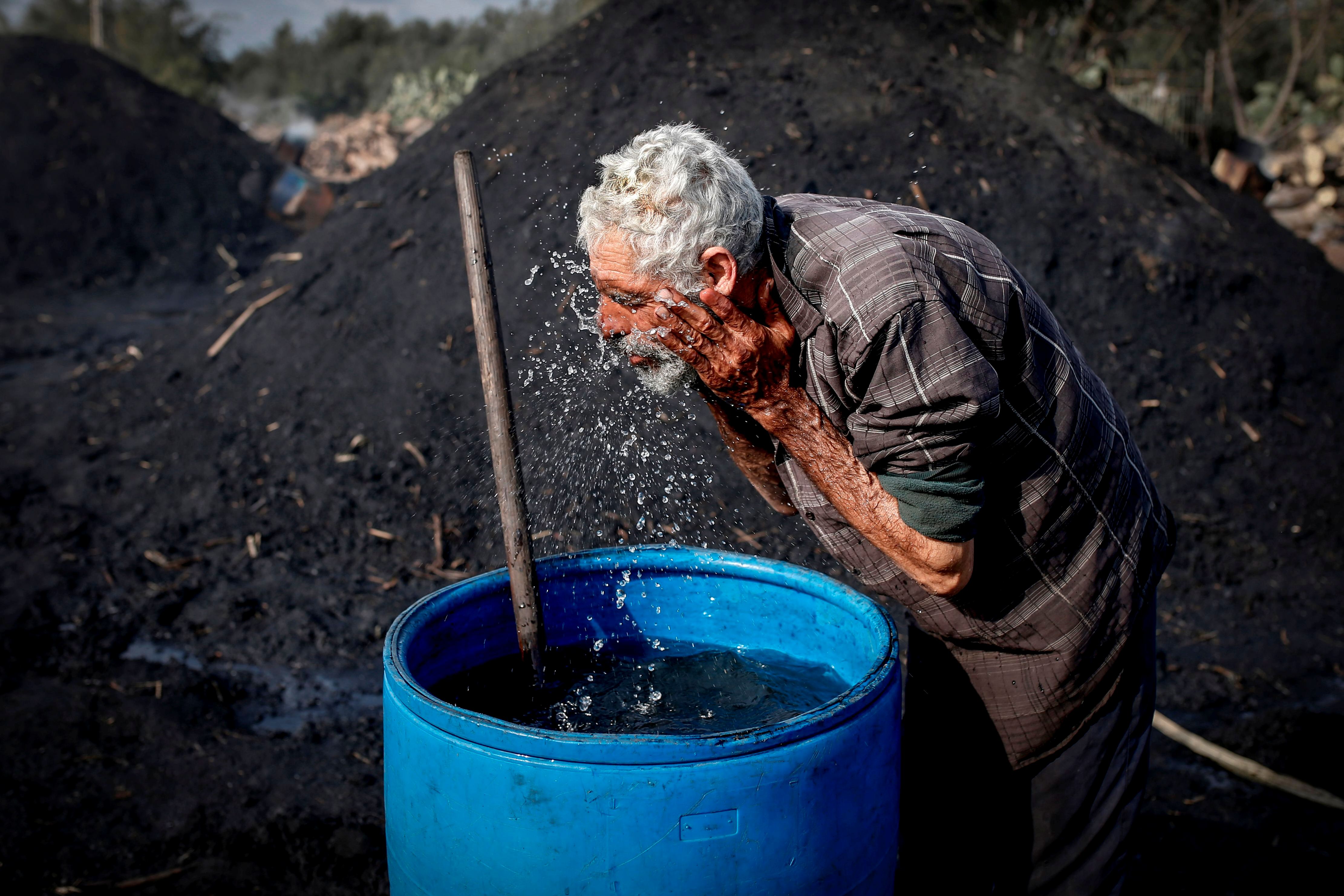 Seorang pekerja Palestina mencuci wajahnya saat istirahat di fasilitas produksi arang al-Hattab, sebelah timur Kota Gaza, Kamis (28/1).
