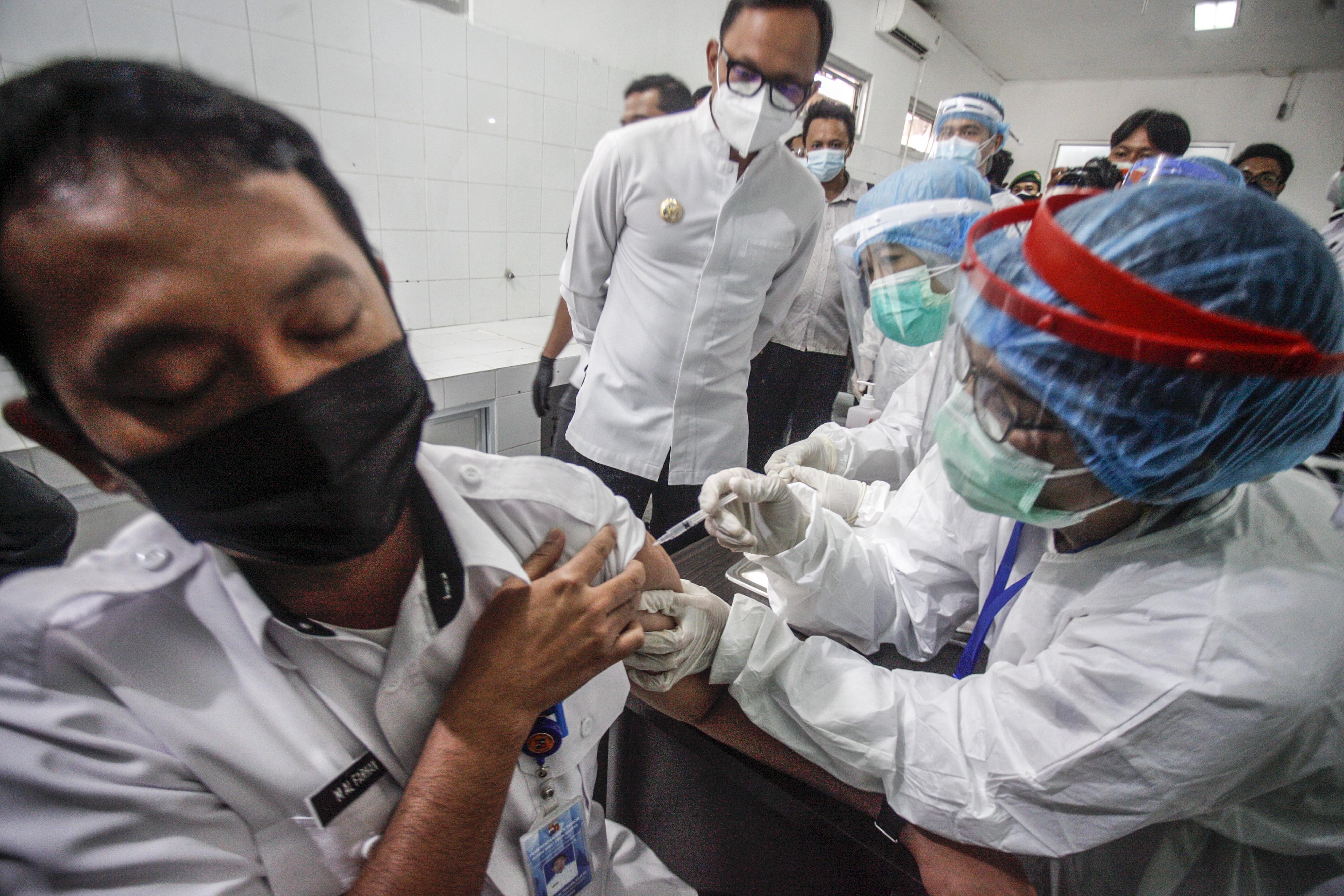 Petugas medis menyuntikan vaksin COVID-19 ke seorang tenaga kesehatan disaksikan Wali Kota Bogor Bima Arya (tengah)