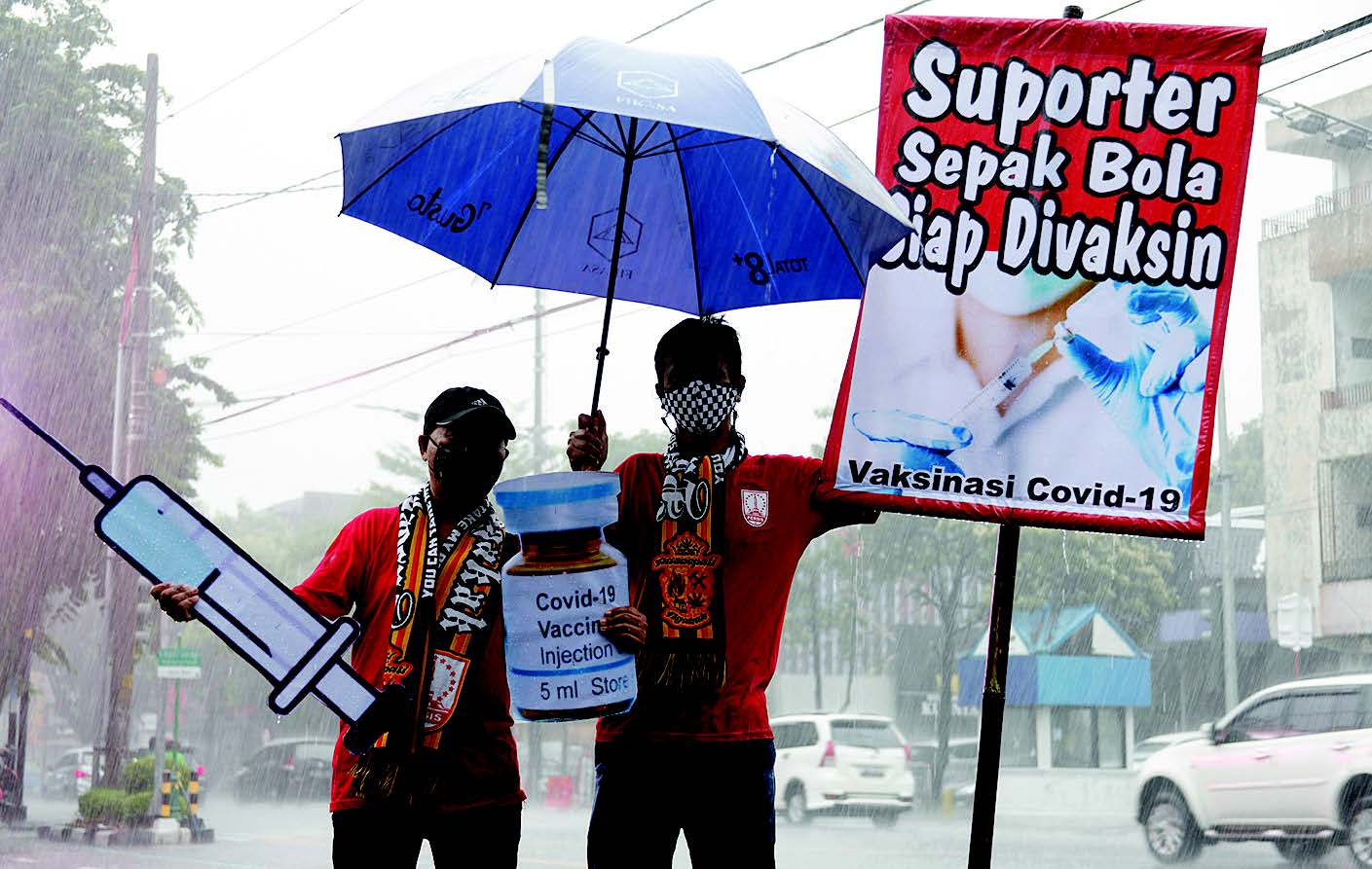 DUKUNG VAKSINASI COVID 19: Suporter sepak bola Pasoepati mengusung poster bertuliskan ‘Suporter Sepak Bola Siap Divaksin’ 
