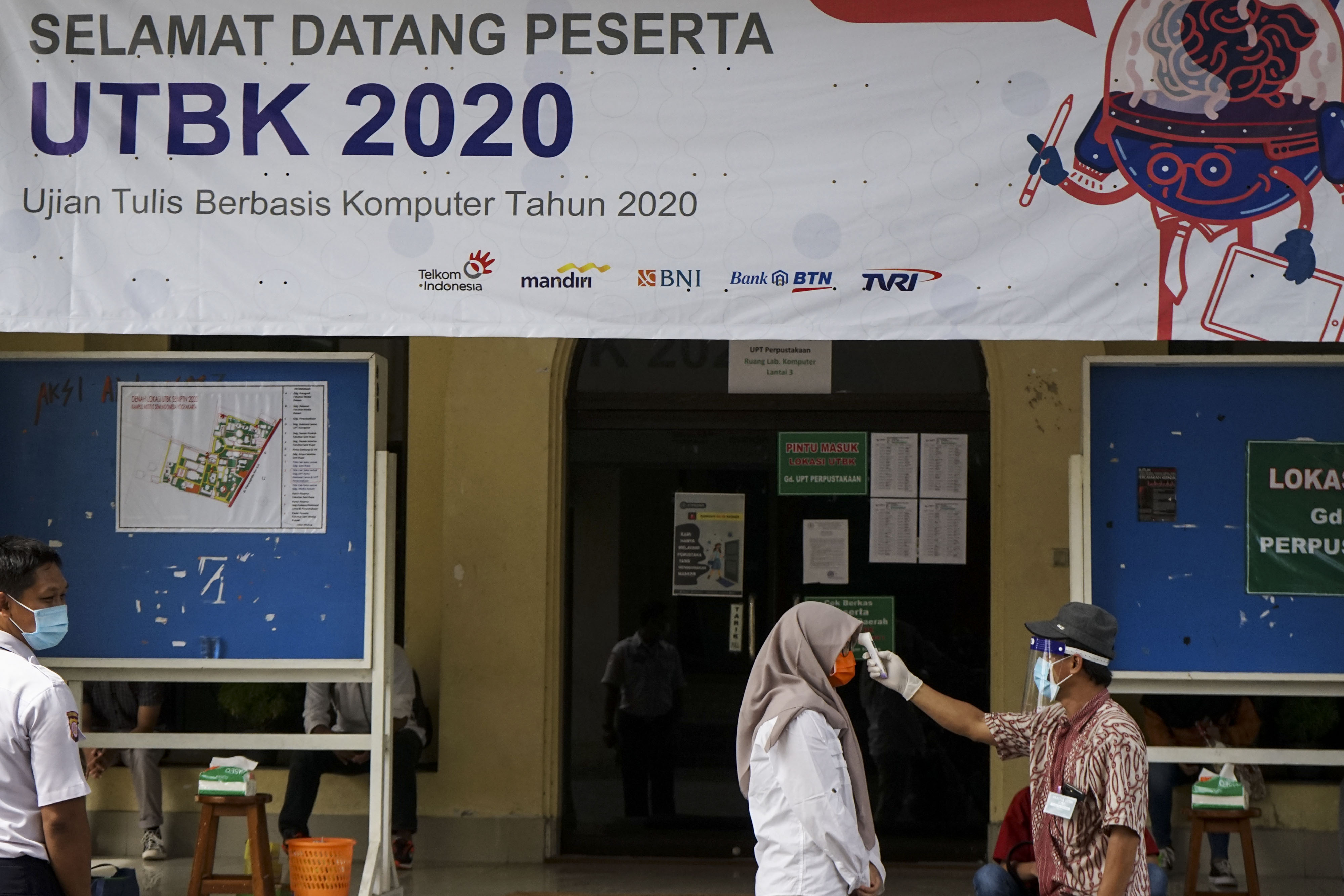 Petugas mengukur suhu tubuh peserta yang akan mengikuti UTBK di Institut Seni Indonesia (ISI) Yogyakarta, Bantul, DIY, Selasa (7/7).